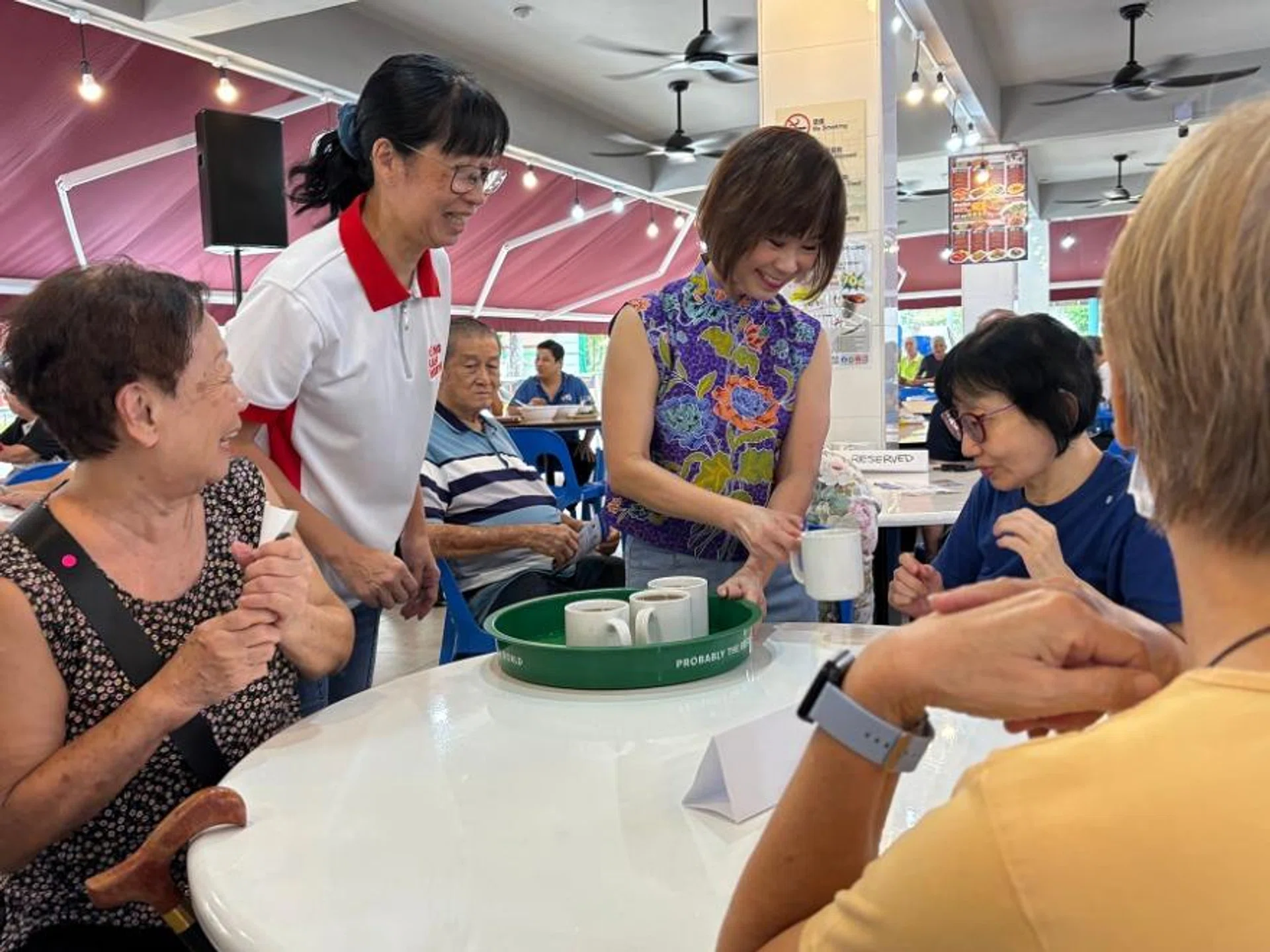 Dr Amy Khor serving seniors their drinks during the launch.