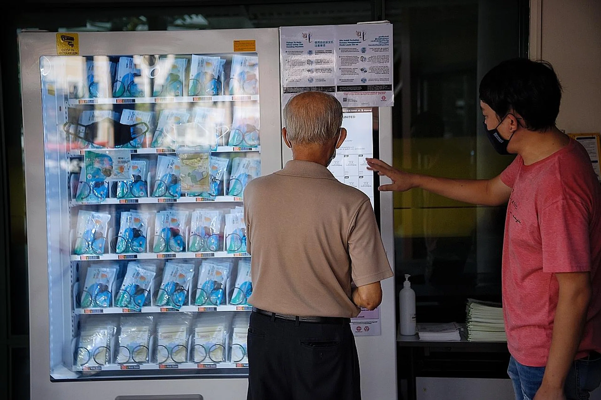 An elderly man collecting his reusable mask from a vending machine at Bishan Community Club yesterday. 