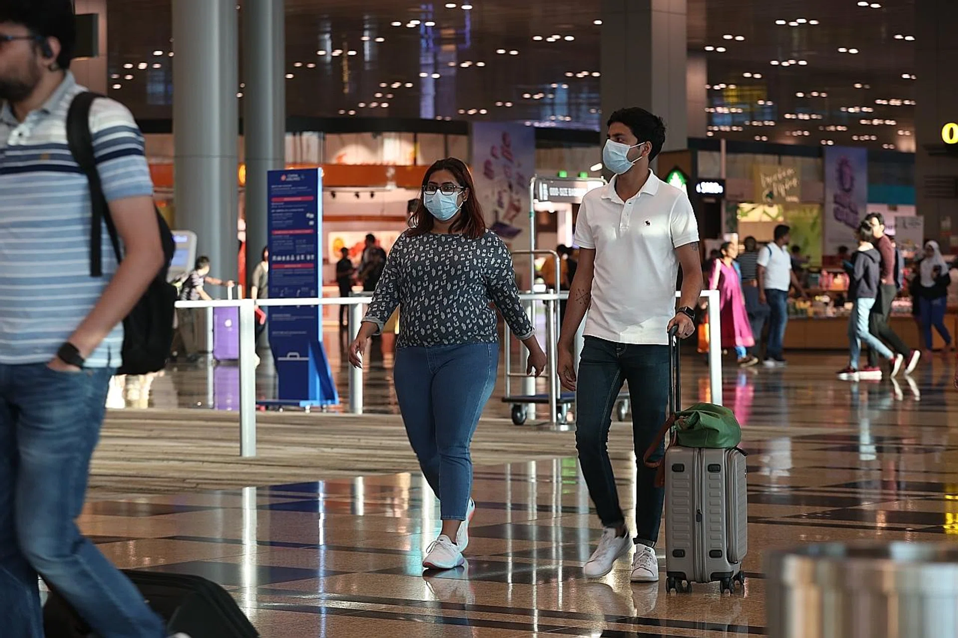 Travellers wearing masks at Changi Airport Terminal 3. The Ministry of Health has announced an entry ban on travellers who have been in Hubei recently or who have a Chinese passport issued in Hubei. 