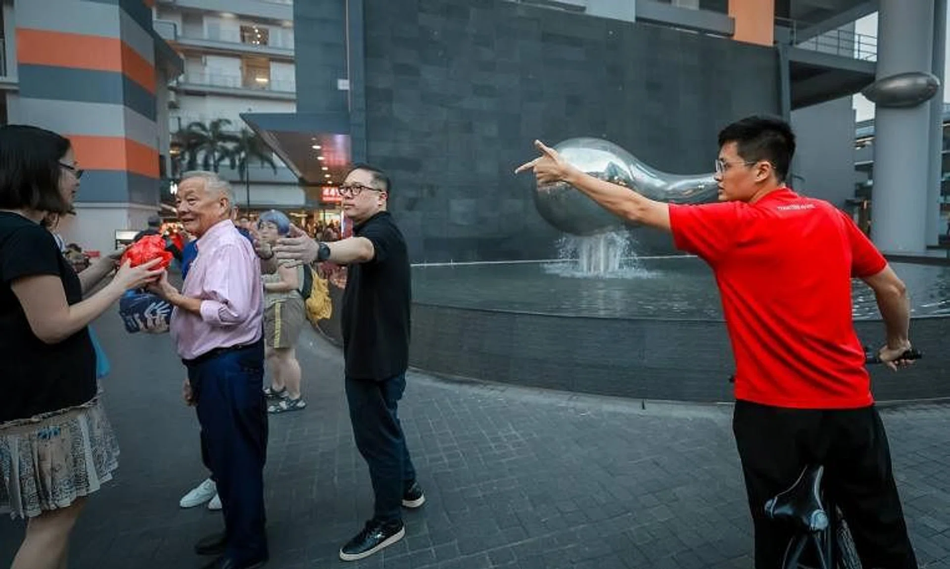 Presidential candidate Ng Kok Song being heckled by a man on a bicycle while Mr Ng was taking pictures with the public at Clementi Central, on Aug 29, 2023.