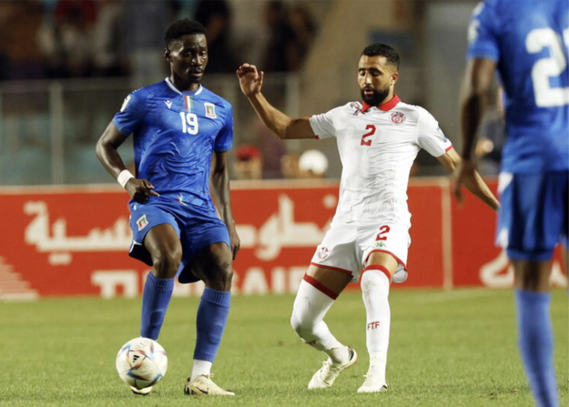 Tunisia player Ali Abdi (in white) and Equatorial Guinea player Luis Asue.