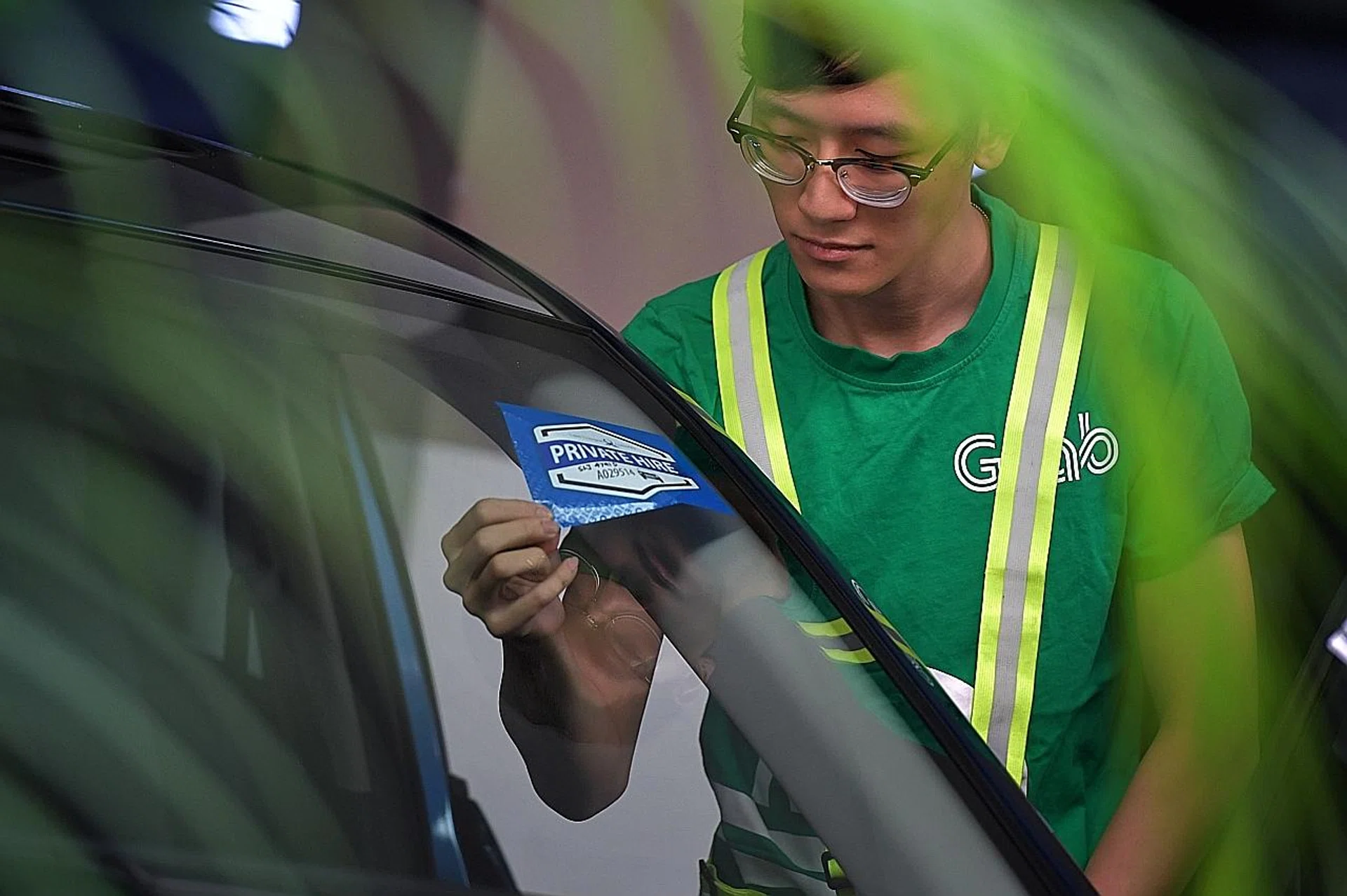 Private-hire car drivers must display these decals to identify themselves. 