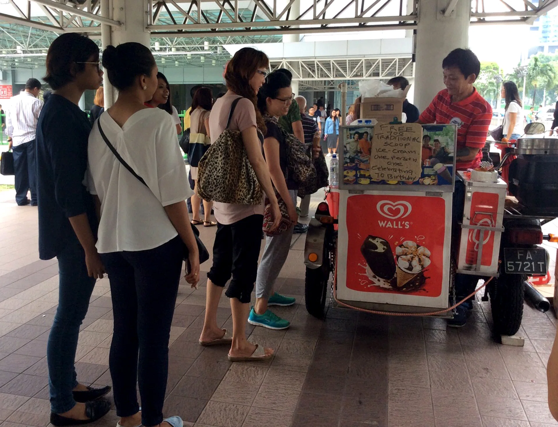 HIS TREAT: Customers queueing for Mr Jimmy Teng’s free ice cream outside Lavender MRT station.