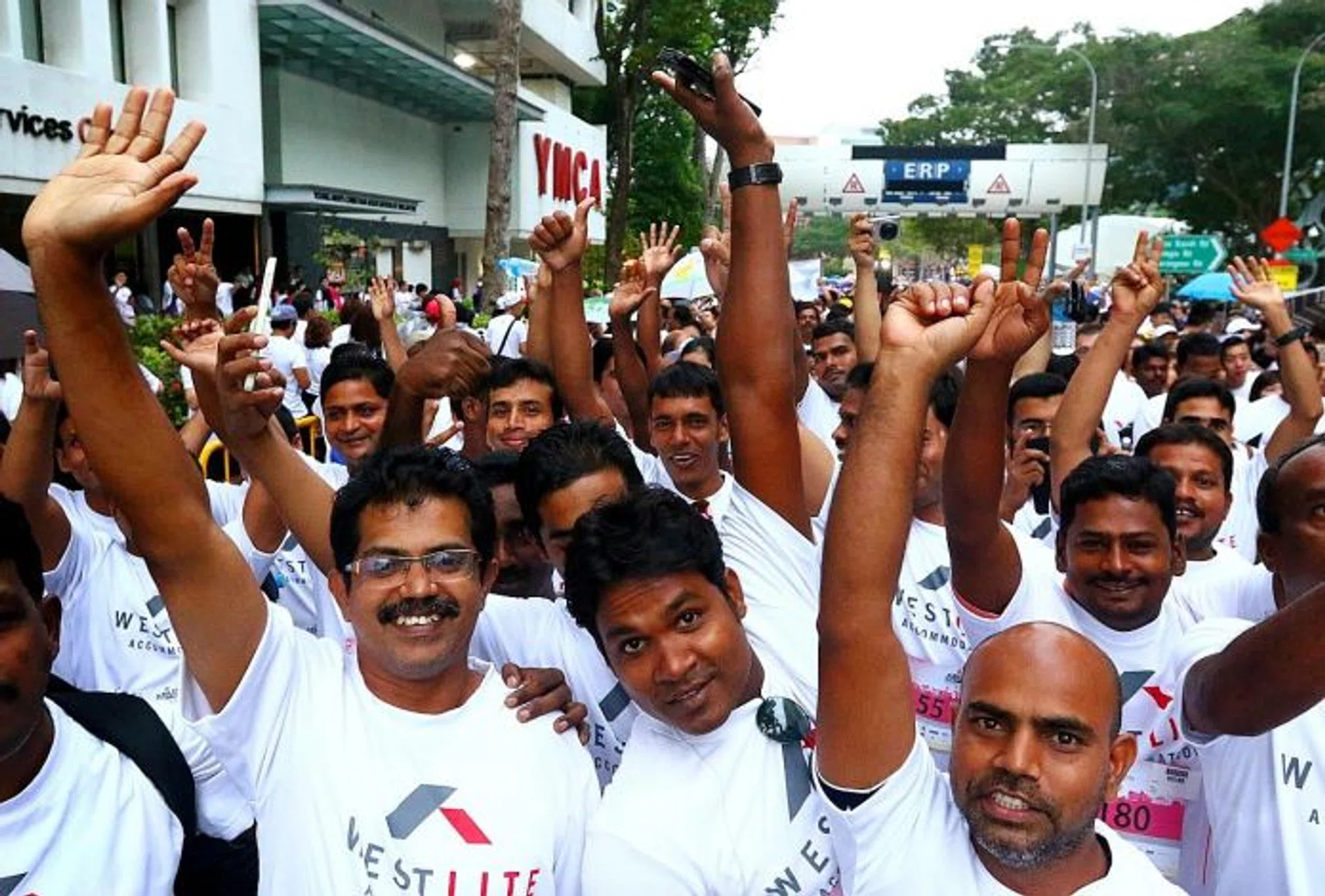 HARMONY: Foreign workers from Westlite Dormitory waving to the camera during the SG50 Jubilee Big Walk last November.