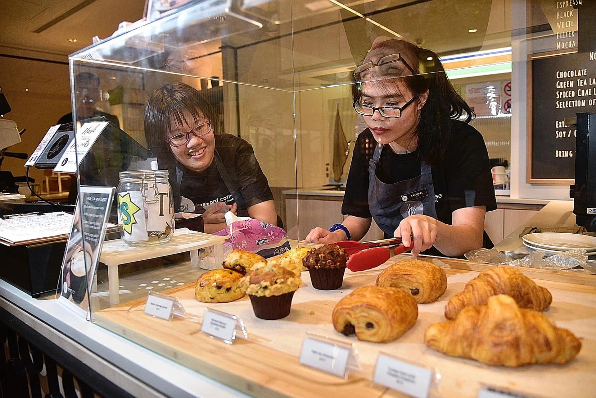 (From left) Ms Carmen Tan Yin Xin and Ms Rachel Lum Yuan Ting are employees with special needs who work at Foreword Coffee. 