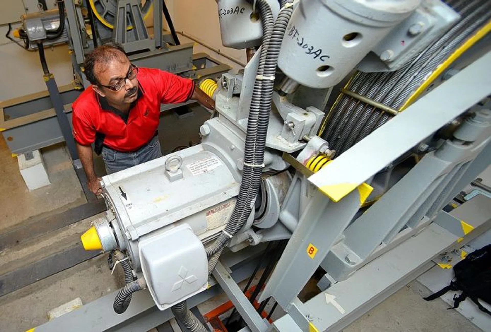 CHECKS: Building and Construction Authority engineer Raja Lakshmanan checking the machines in a lift motor room.