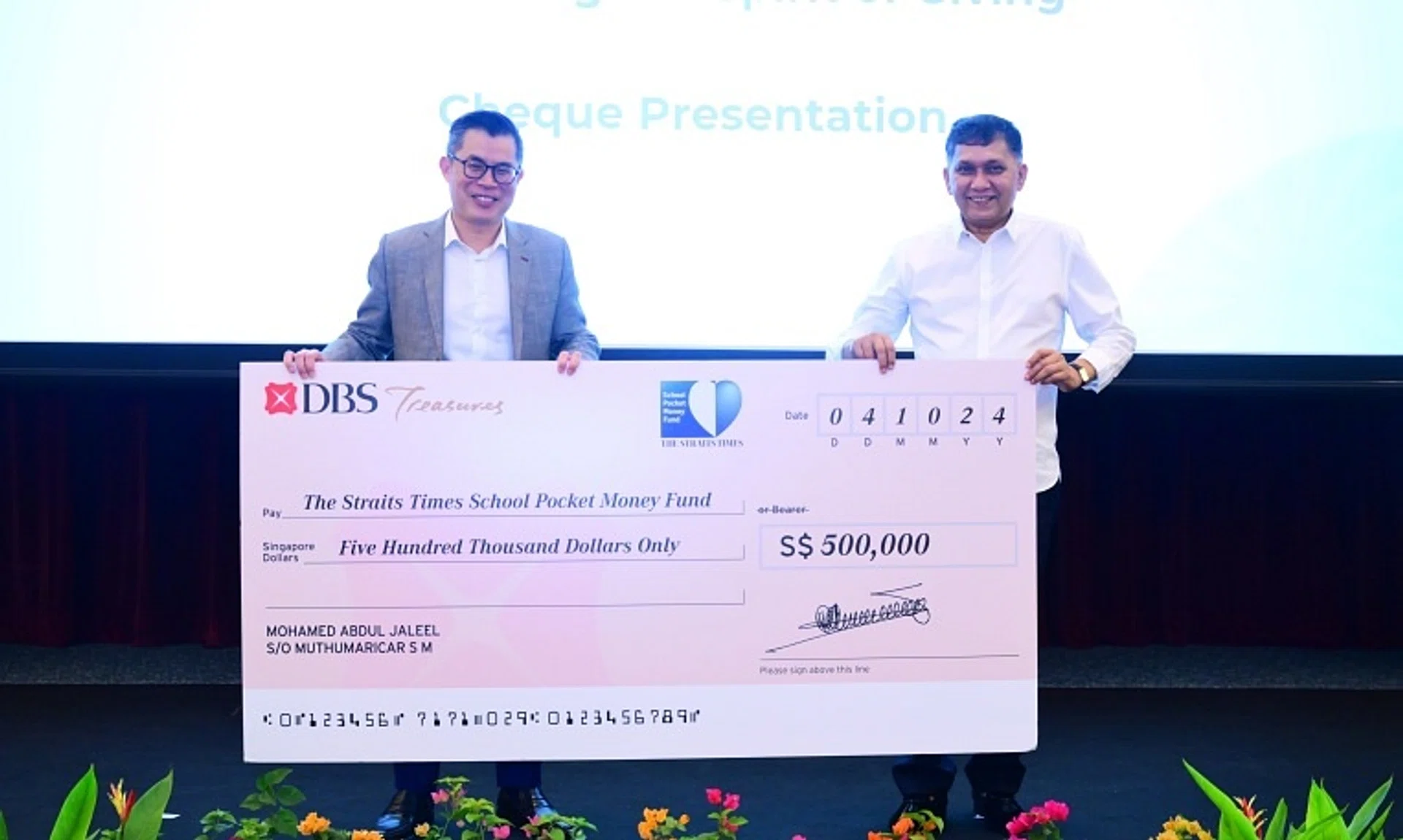 MES Group founder and chief executive Mohamed Abdul Jaleel Muthumaricar S M (right) presents a cheque to ST editor Jaime Ho at the appreciation lunch on Oct 4.