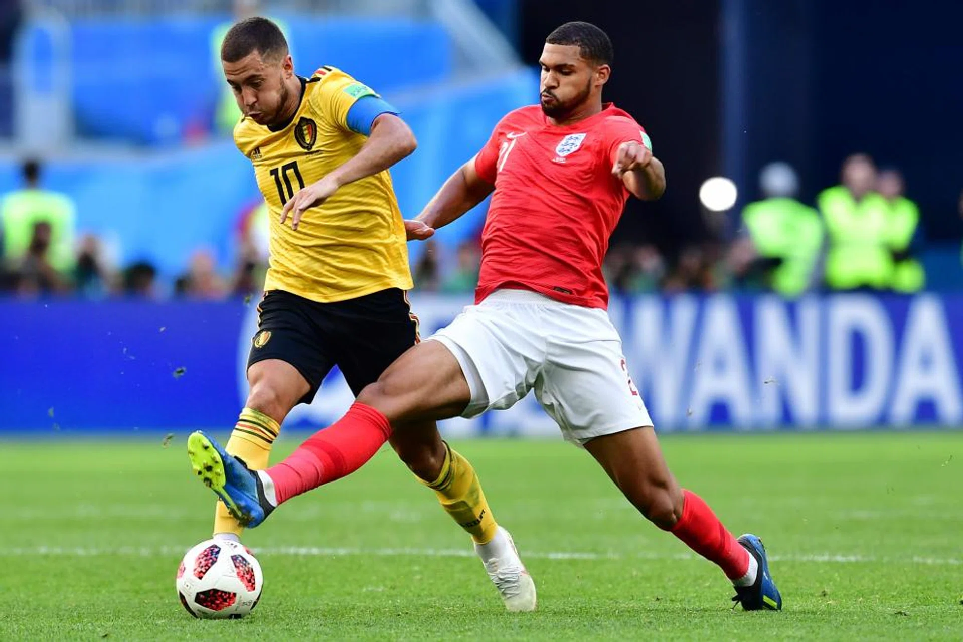 Belgium's Eden Hazard shaking off the challenge of England's Ruben Loftus-Cheek.