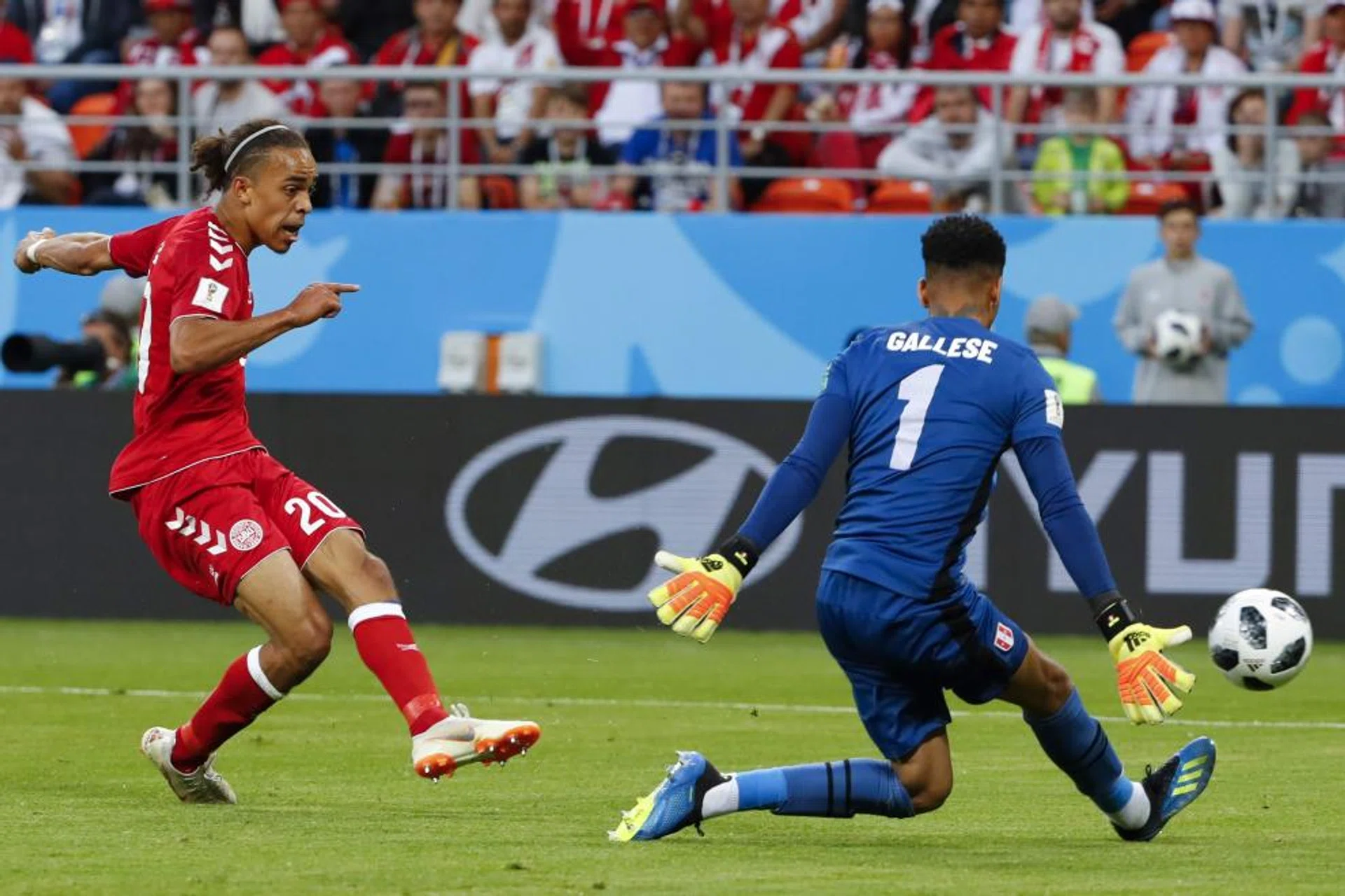 Denmark's forward Yussuf Poulsen (left) scoring a goal past Peru's goalkeeper Pedro Gallese.