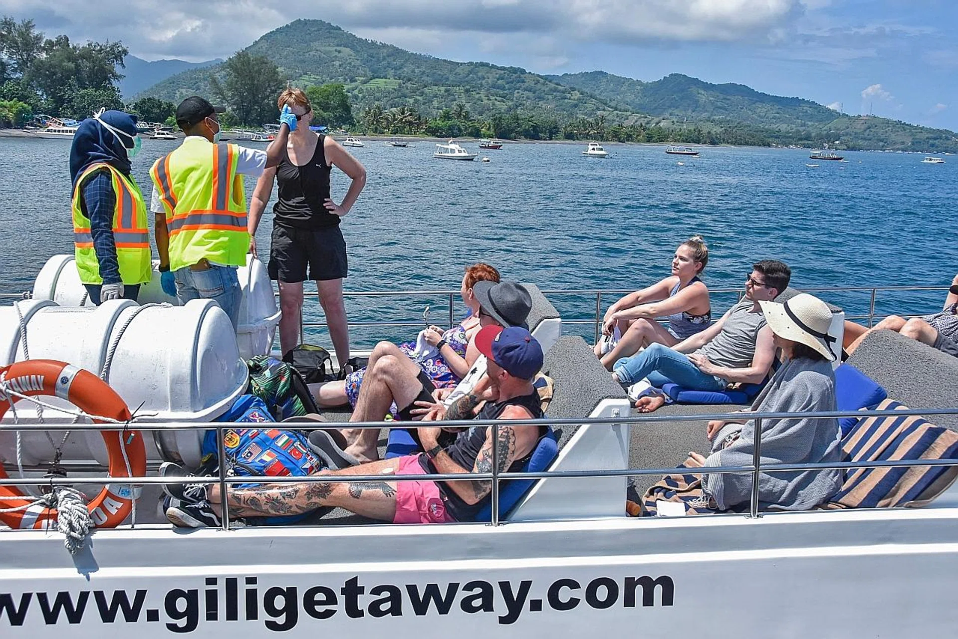 Indonesian health officials checking the body temperature of tourists arriving from Bali island. 
