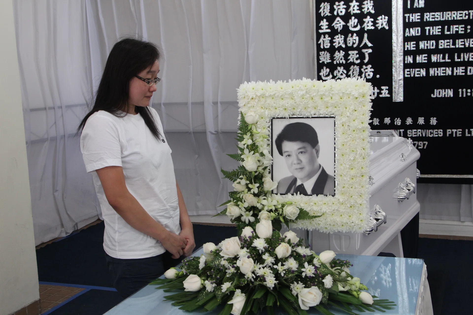 A WIFE’S GOODBYE: (Above) Mrs Angeline Aw at her husband’s wake.