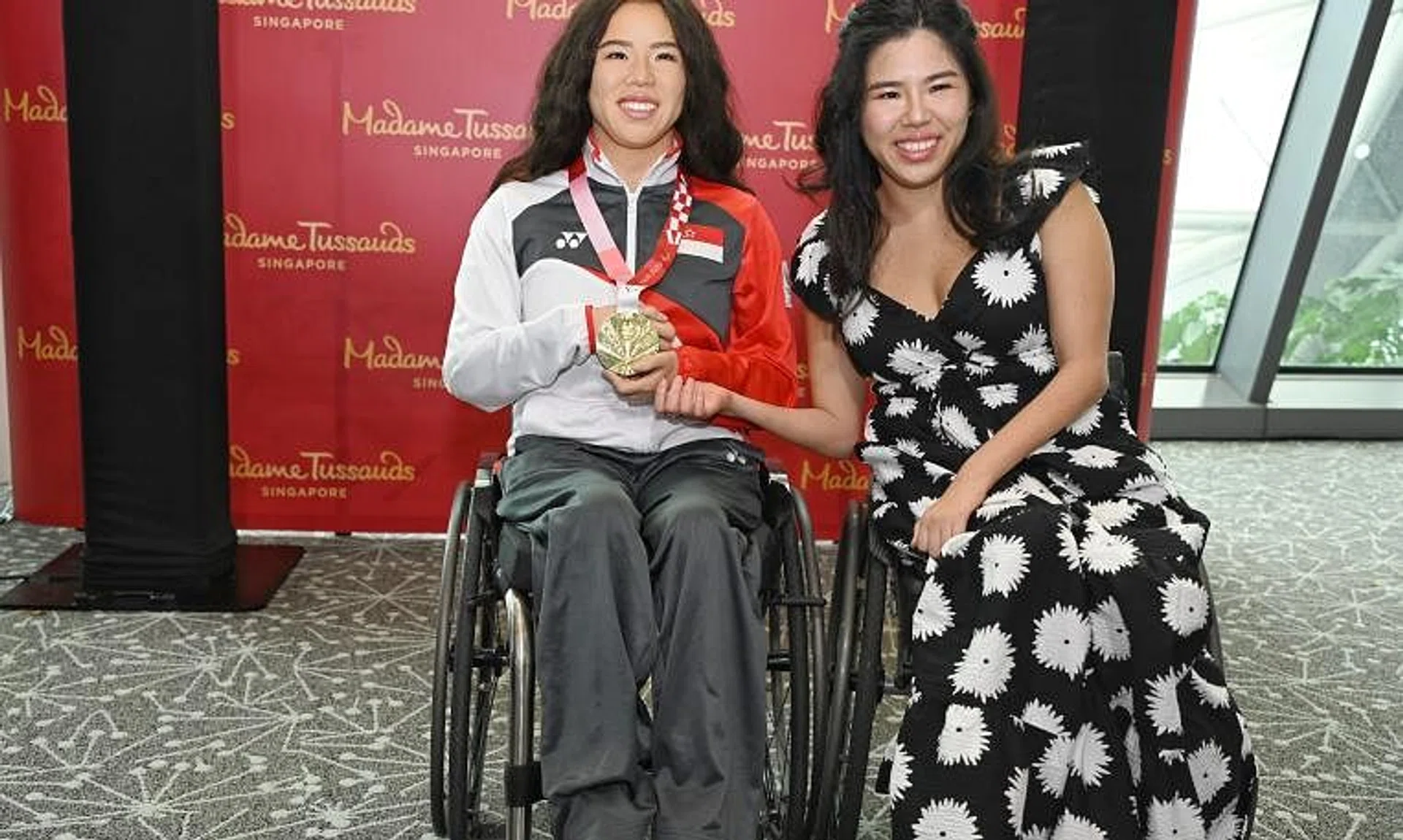 Yip Pin Xiu posing with Madame Tussaud's waxwork of her after the unveiling of the 2025 World Para Swimming Championships host city.