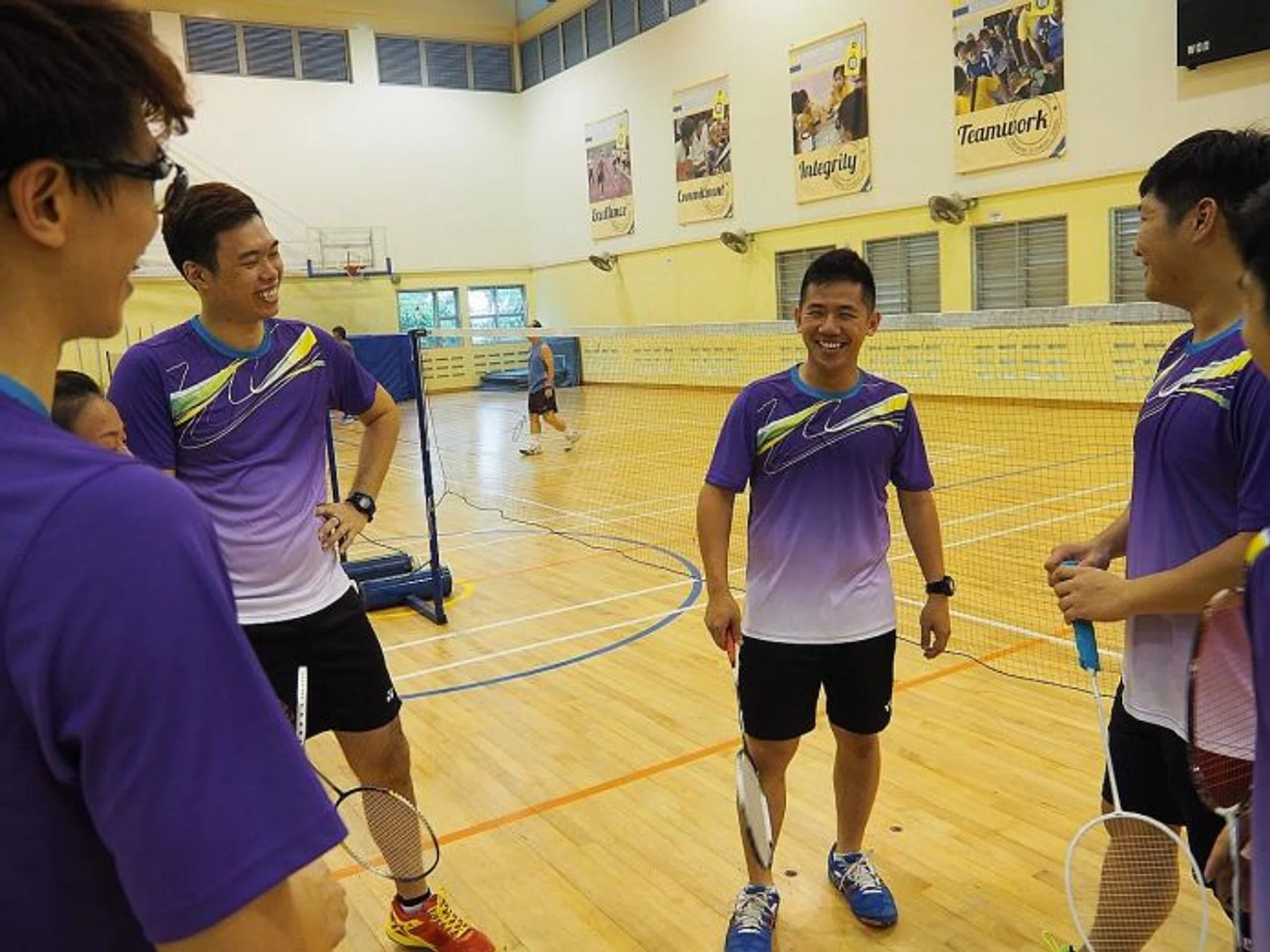 EASING THE CRUNCH:  Former national doubles player Derrick Toh (centre) is glad that it will be easier to find venues for his badminton sessions.