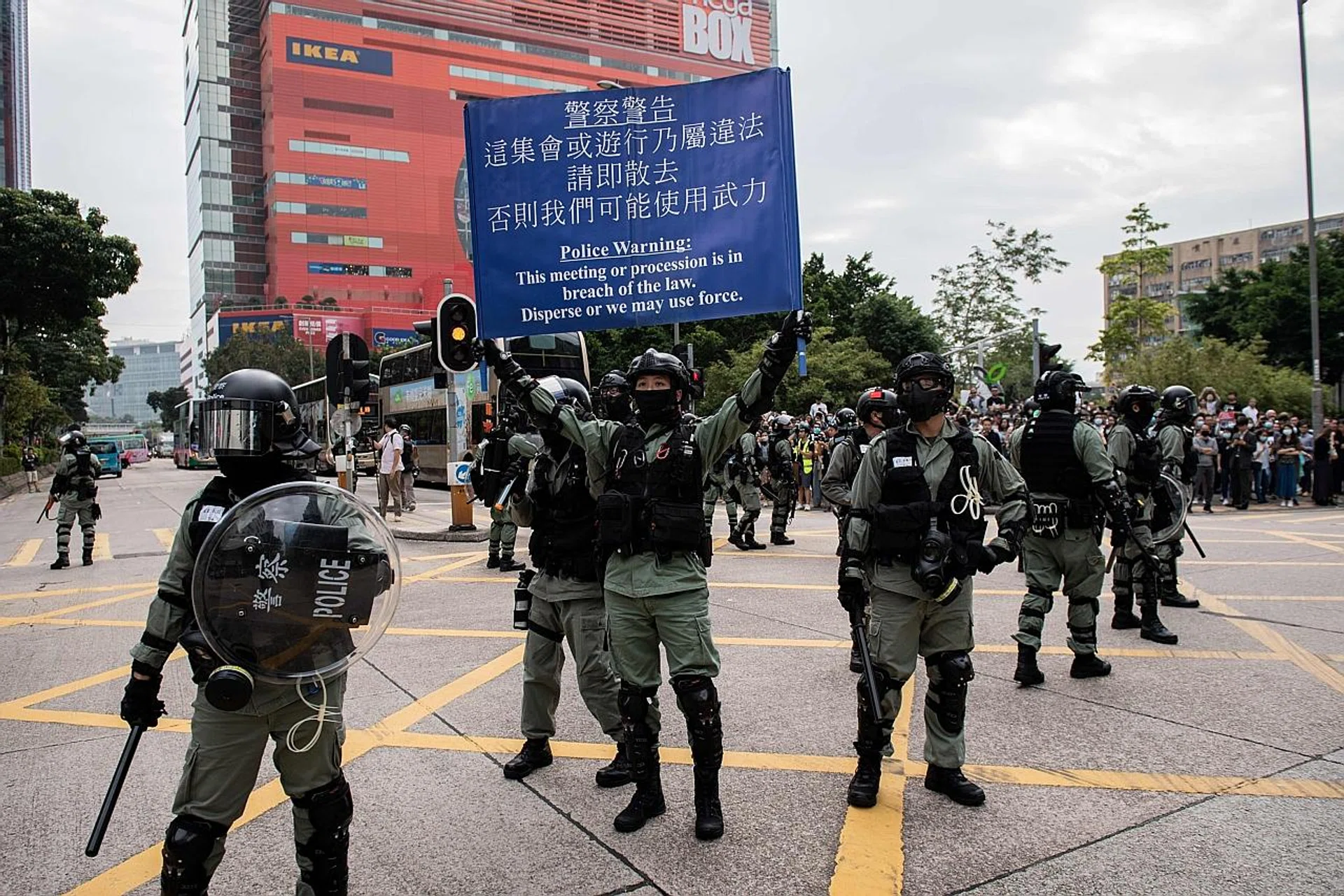 Riot police trying to disperse people gathering in support of pro-democracy protesters during a lunch break rally in the Kowloon Bay area in Hong Kong yesterday.
