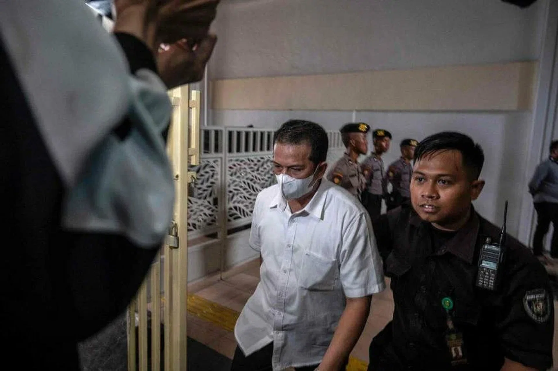 Police officer Hasdarmawan (centre) arriving for his trial at a courthouse in Surabaya, Indonesia, on March 16, 2023. PHOTO: AFP
