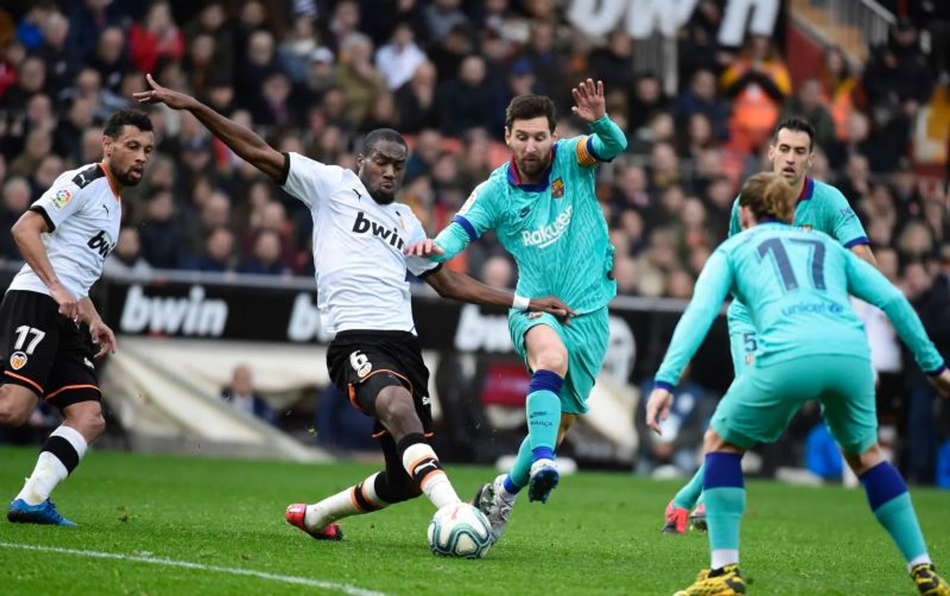 Valencia midfielder Geoffrey Kondogbia (left) challenging Barcelona's superstar Lionel Messi.