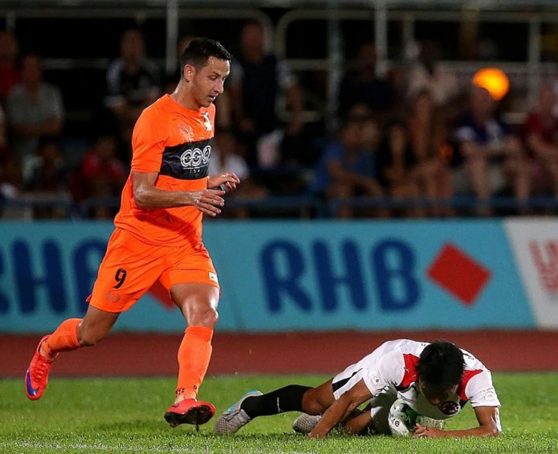 KILLER TOUCH: Hougang United forward Stipe Plazibat (in orange) condemning Home United to their first defeat.  
