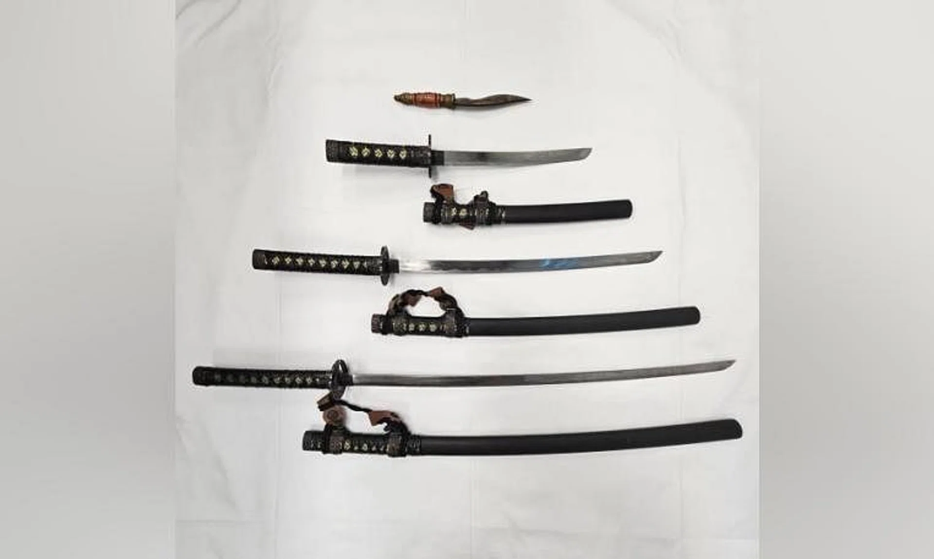 The men were arrested for alleged illegal possession of scheduled weapons including a kukri (knife) and three katana (swords).