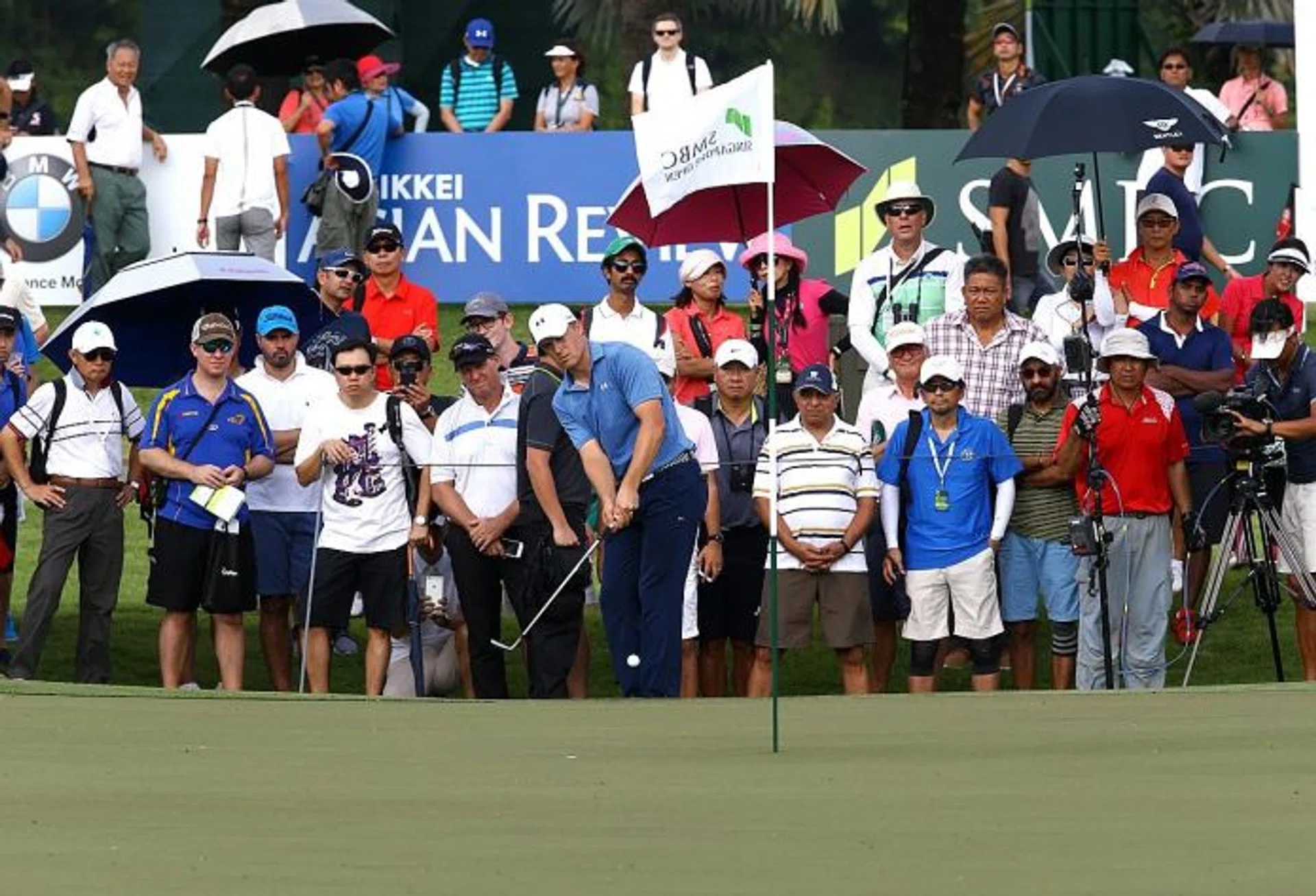 CROWD-PULLER: All eyes are on Jordan Spieth (holding club) on the first day of the SMBC Singapore Open.