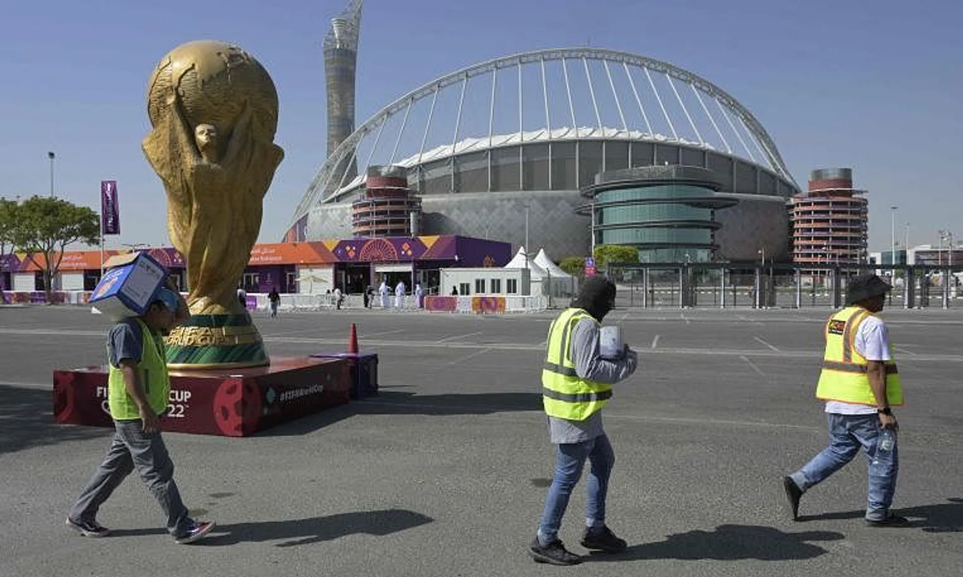 Workers walk past the Khalifa International Stadium in Doha ahead of the Qatar 2022 World Cup football tournament, which begins on Sunday.