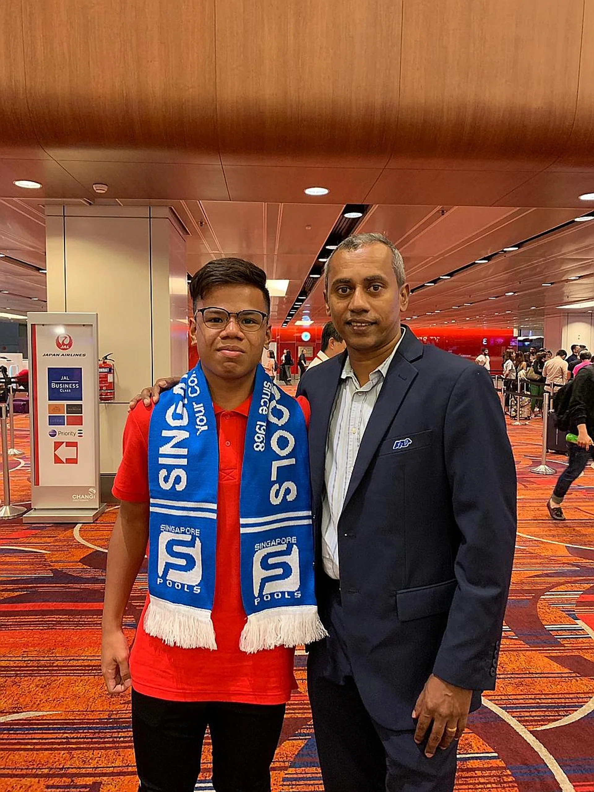 TNP Dollah Kassim Award 2018 winner Nur Adam Abdullah (left), with FAS general manager of youth development S. Varatha Rajan before their flight to Belgium last night. 