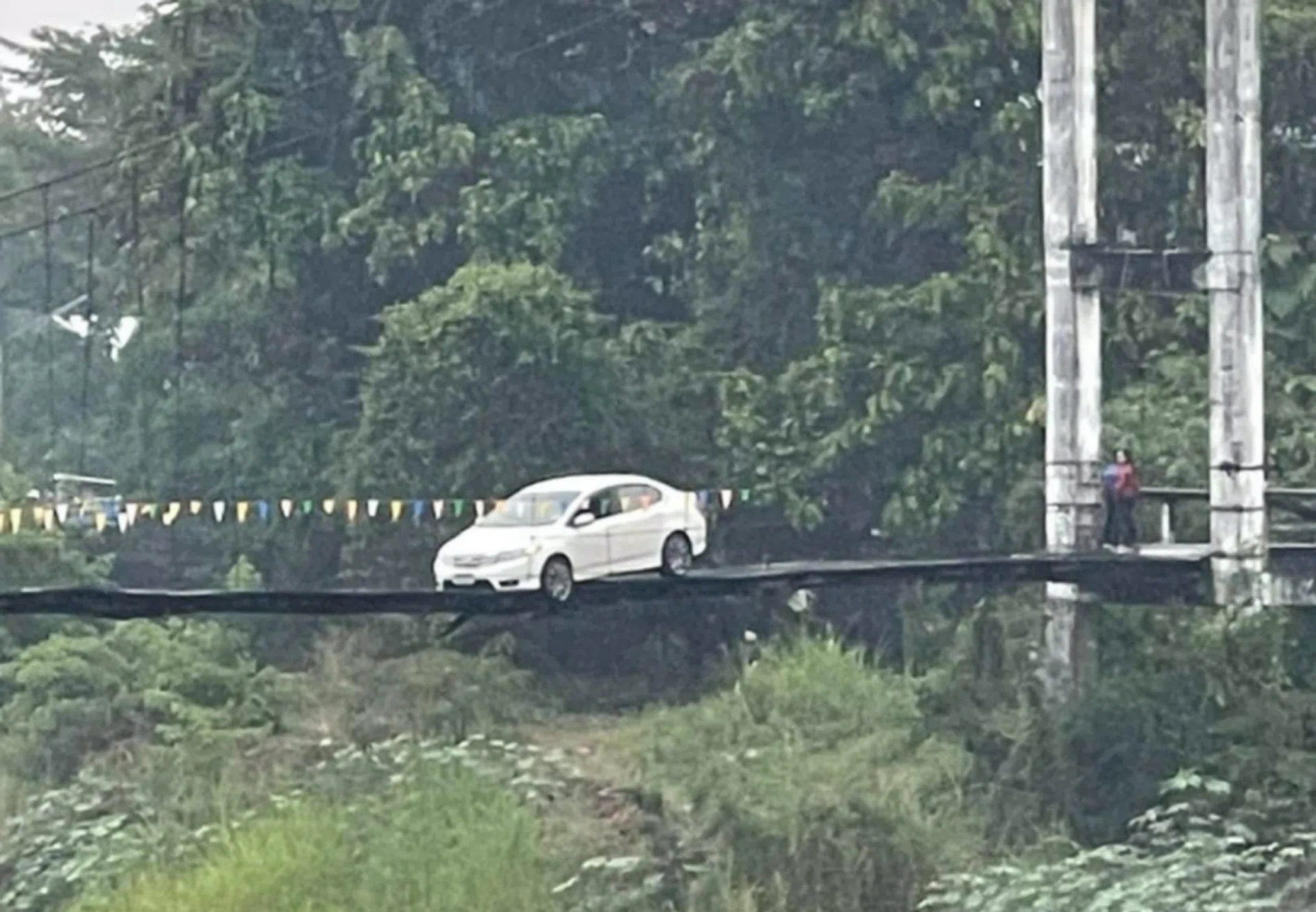 The car on the suspension bridge over Yom River.