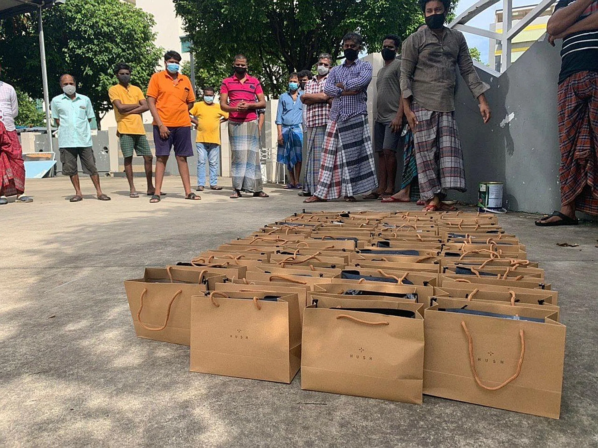 Self-care kits being distributed to workers from the dormitory at 35 Tuas View Walk 2 on Sunday. Founder of Hush TeaBar and former nominated MP Anthea Ong showing Bangladeshi worker Rasel Mirza the items inside the kit. 