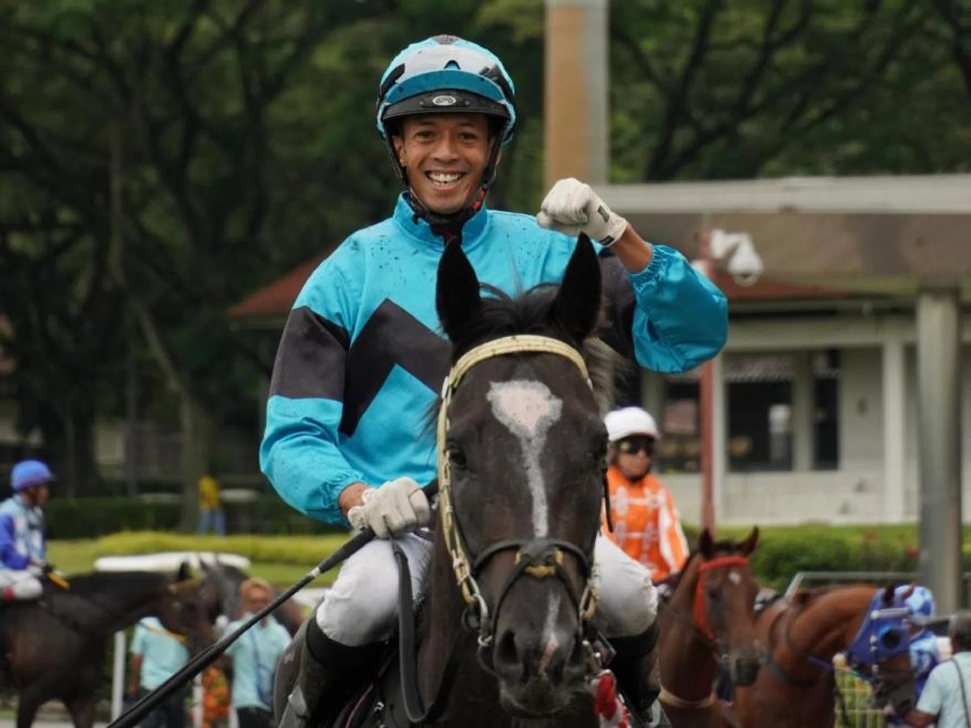 Jockey Darren Danis punching the air in delight as he brings to scale his first Singapore winner, $116 long shot Run Buddy Run, at Kranji on June 22.
