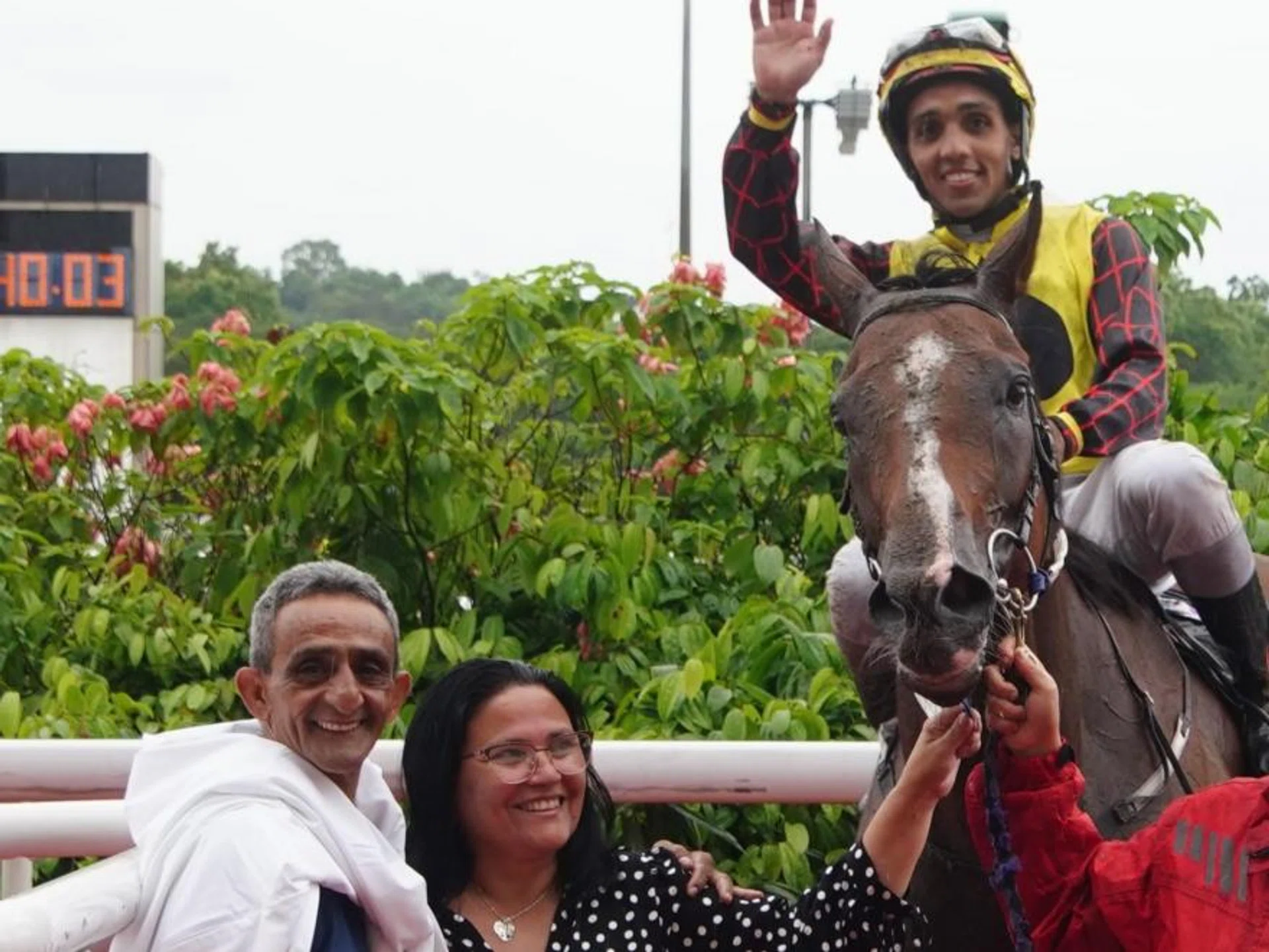 Bruno Queiroz saluting aboard his May 4 winner Free And Happy with his proud parents Antonio, also a jockey, and Sandra by his side.

