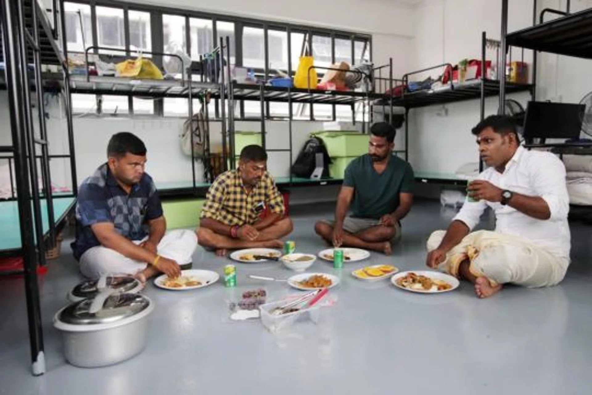 Migrant worker Karthikeyan (right) having lunch with his colleagues at the dormitory during the Deepavali celebrations at Westlite Mandai dorm on Nov 4, 2021.