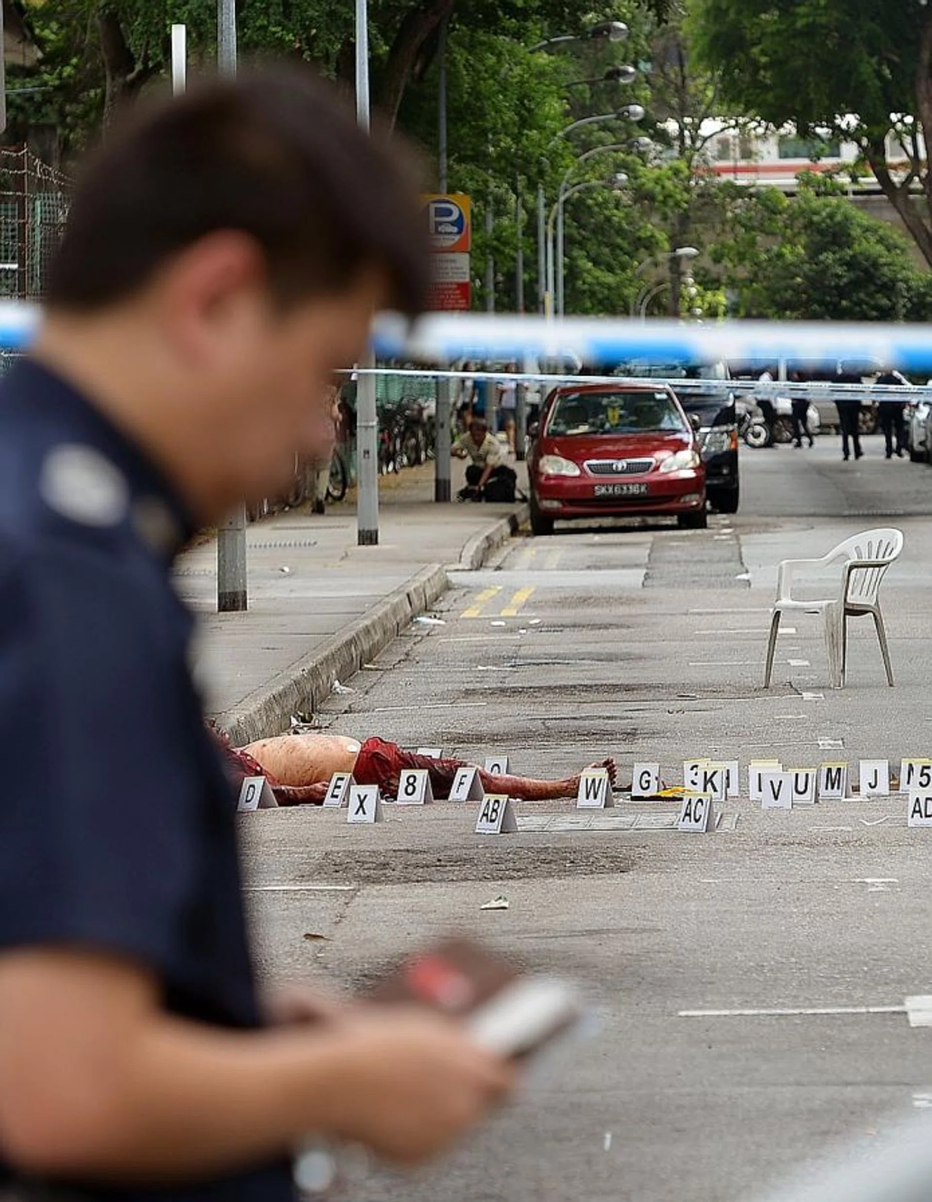 EXPOSED: (Above) Mr Niu-ge's bloodied body at the roadside along Lorong 23 Geylang. 