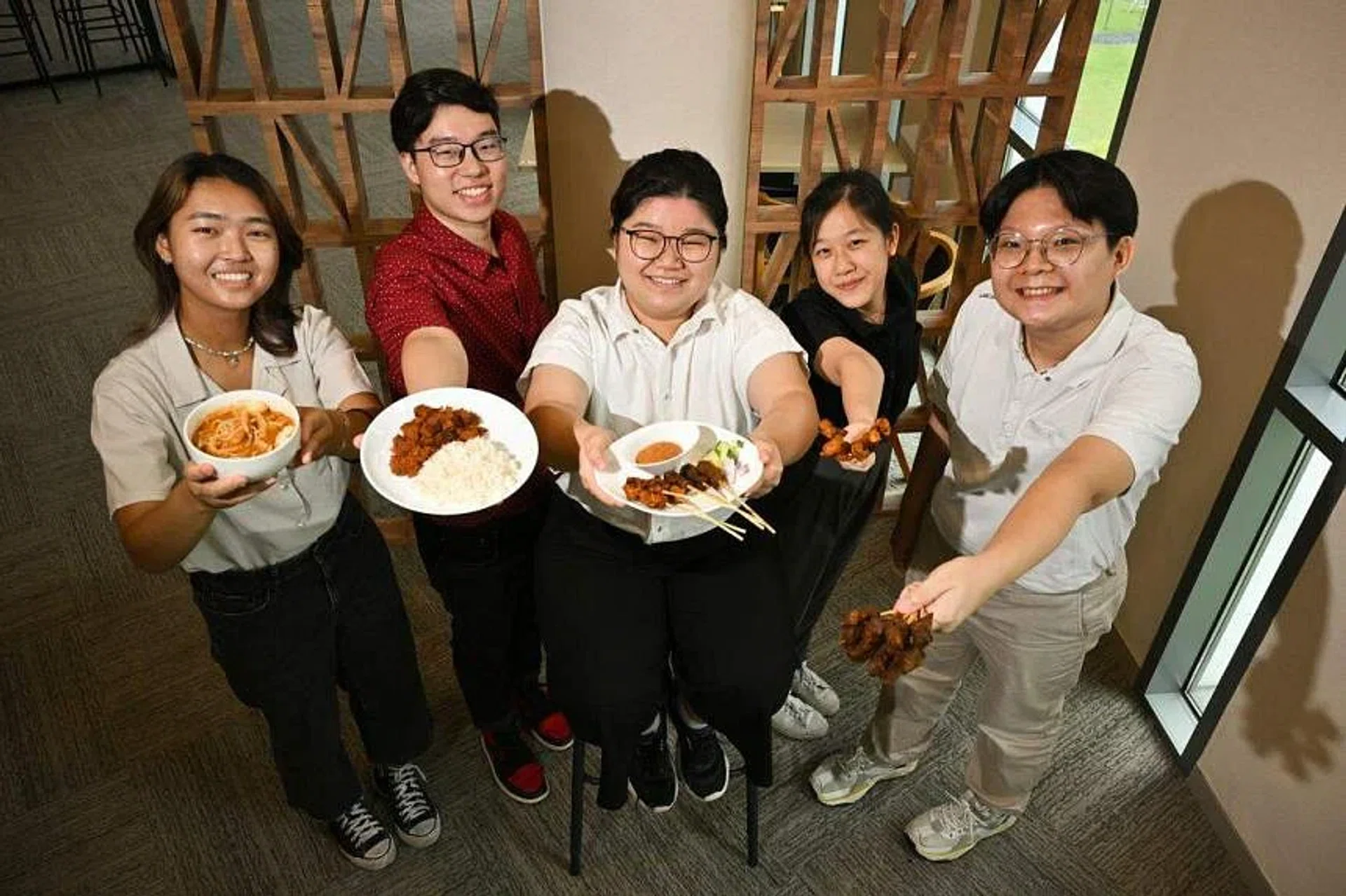 Temasek Polytechnic students (from left) Cheryl Pow, Jacob Ang, Kathleen Tay, Annabel Teo and Benedict Lim with the local dishes they recreated using plant-based proteins. ST PHOTO: LIM YAOHUI
