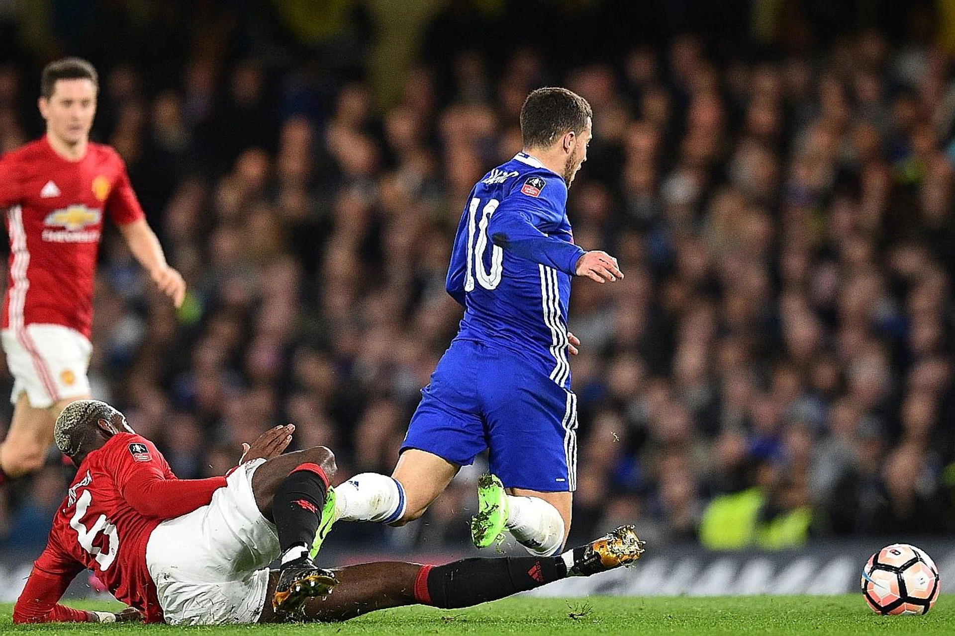 Manchester United's Paul Pogba (above, left) sliding in to tackle Chelsea's Eden Hazard (right). 