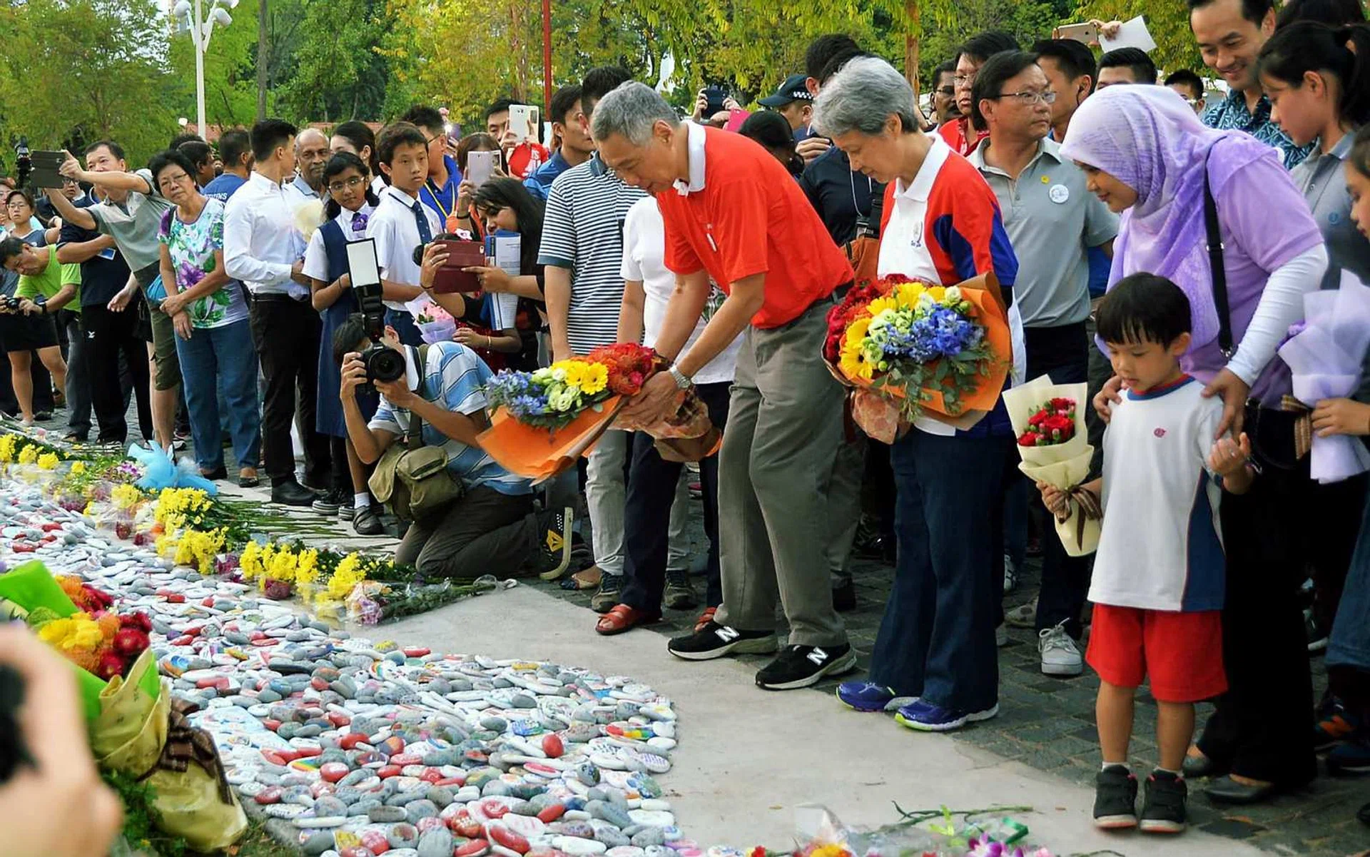 Prime Minister Lee Hsien Loong (in red shirt) and his wife Ho Ching putting flowers at the Garden of Remembrance on March 19 to mark the first anniversary of the passing of Mr Lee Kuan Yew. 