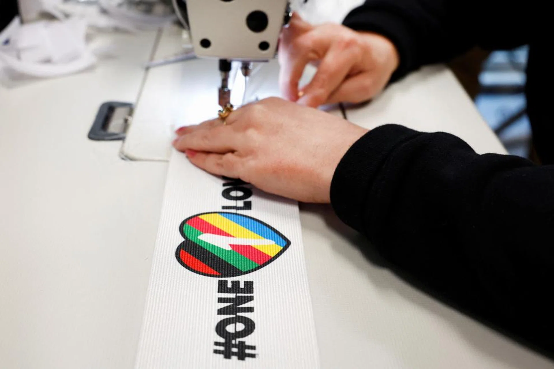 A woman sews velcro on to a One Love armband, which is banned by FIFA at the World Cup Qatar 2022, in Utrecht, Netherlands.