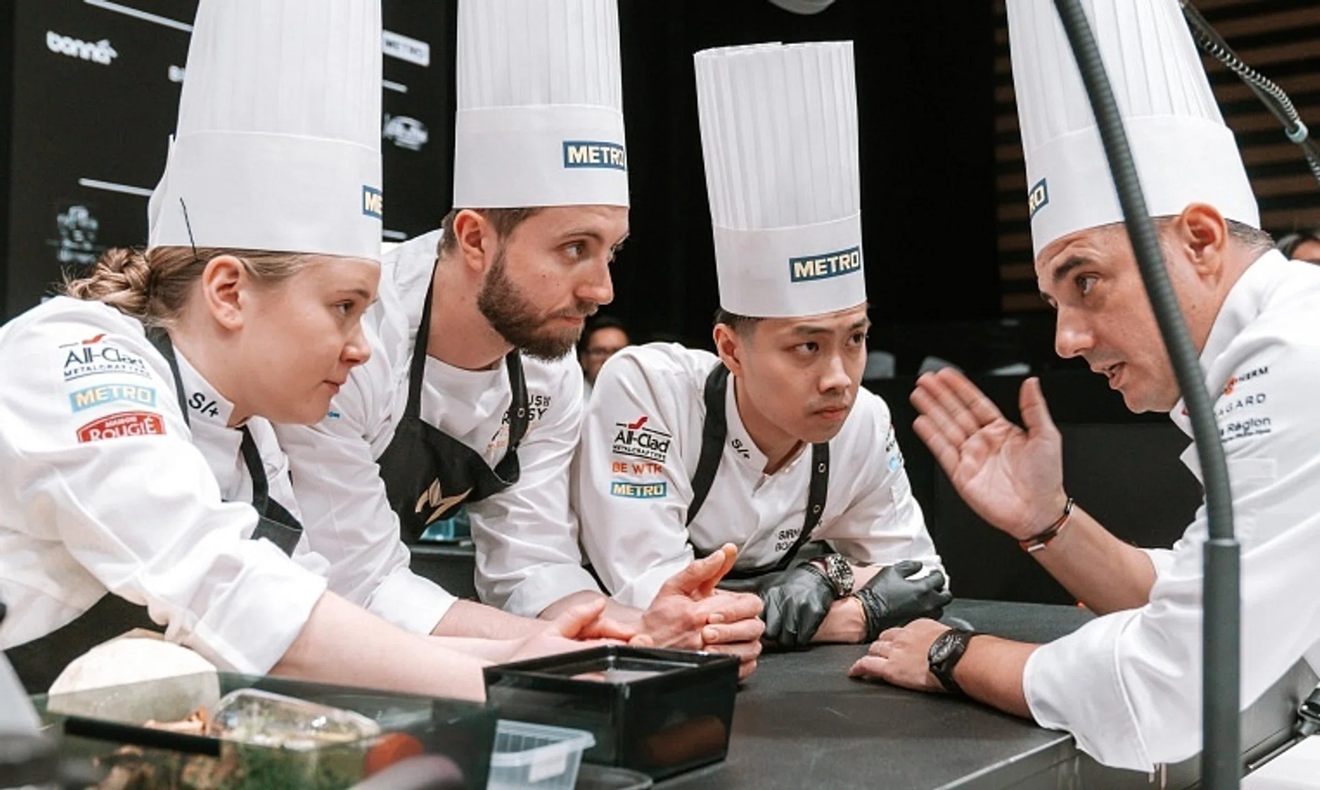Team Singapore co-chair and coach Julien Royer (right) instructing candidate Mathew Leong (second from right) and his team during the Bocuse d’Or final. 