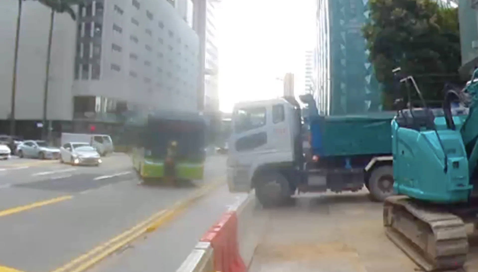 The bus crashes into the worker who has just placed a road cone.