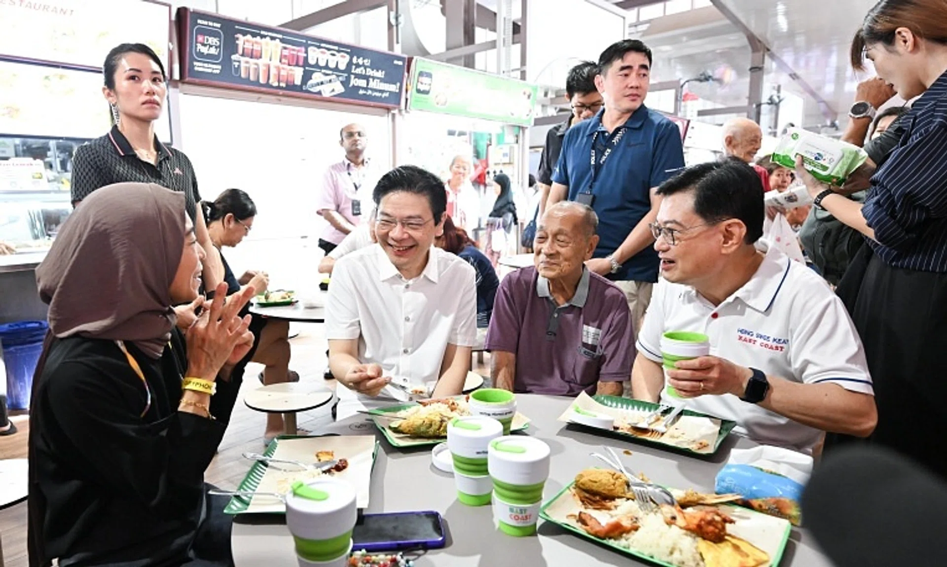 Prime Minister Lawrence Wong (centre) and Deputy Prime Minister Heng Swee Keat (right) having breakfast with stall owners of Azman Seafood Restaurant in New Upper Changi Road on Dec 14.