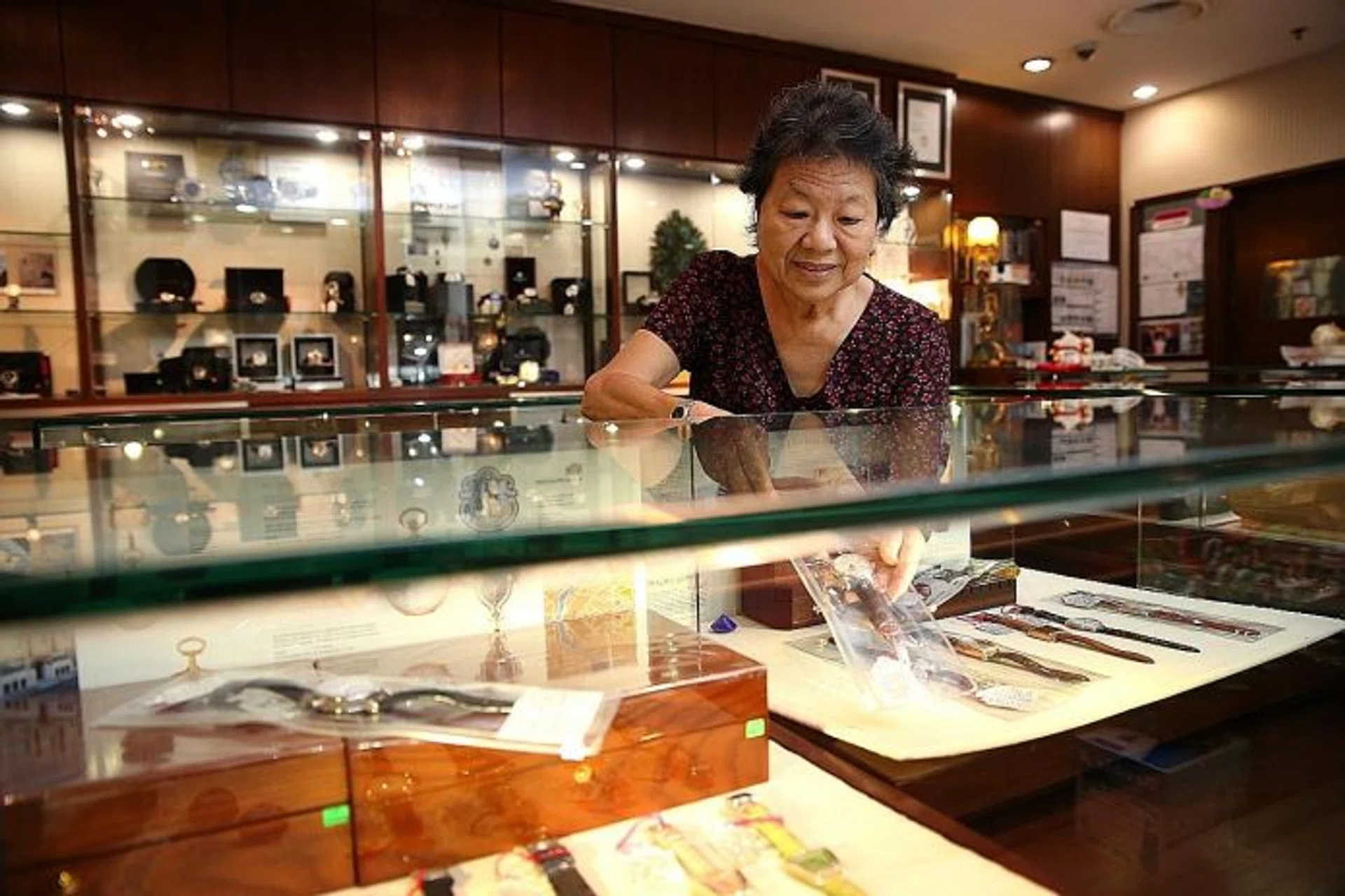 PASSIONATE: Madam Helen Tan painstakingly writes down the details and condition of every second-hand watch put up for sale.