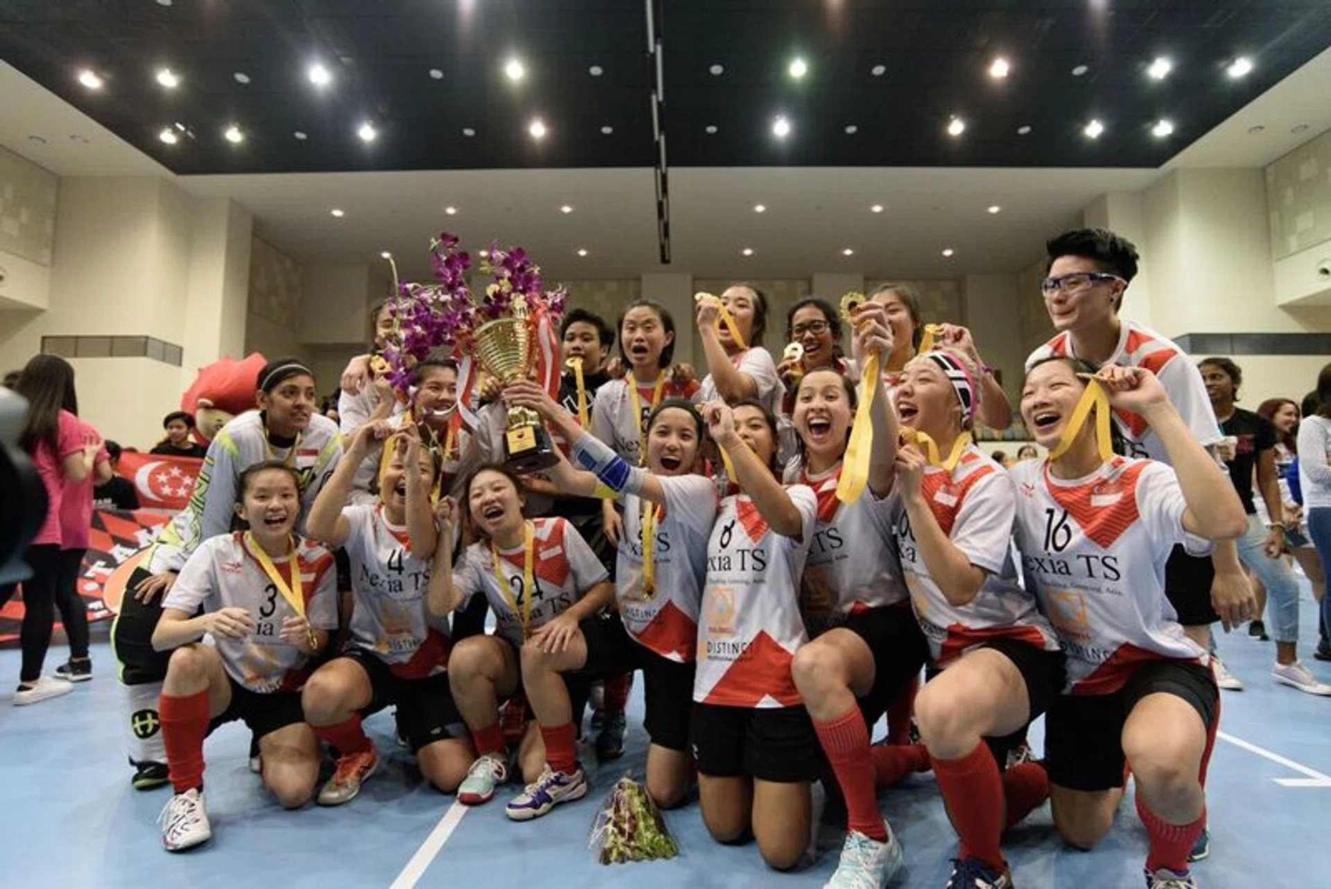 The Singapore women's floorball team celebrating after capturing the Asia-Oceania Floorball Cup on Saturday.