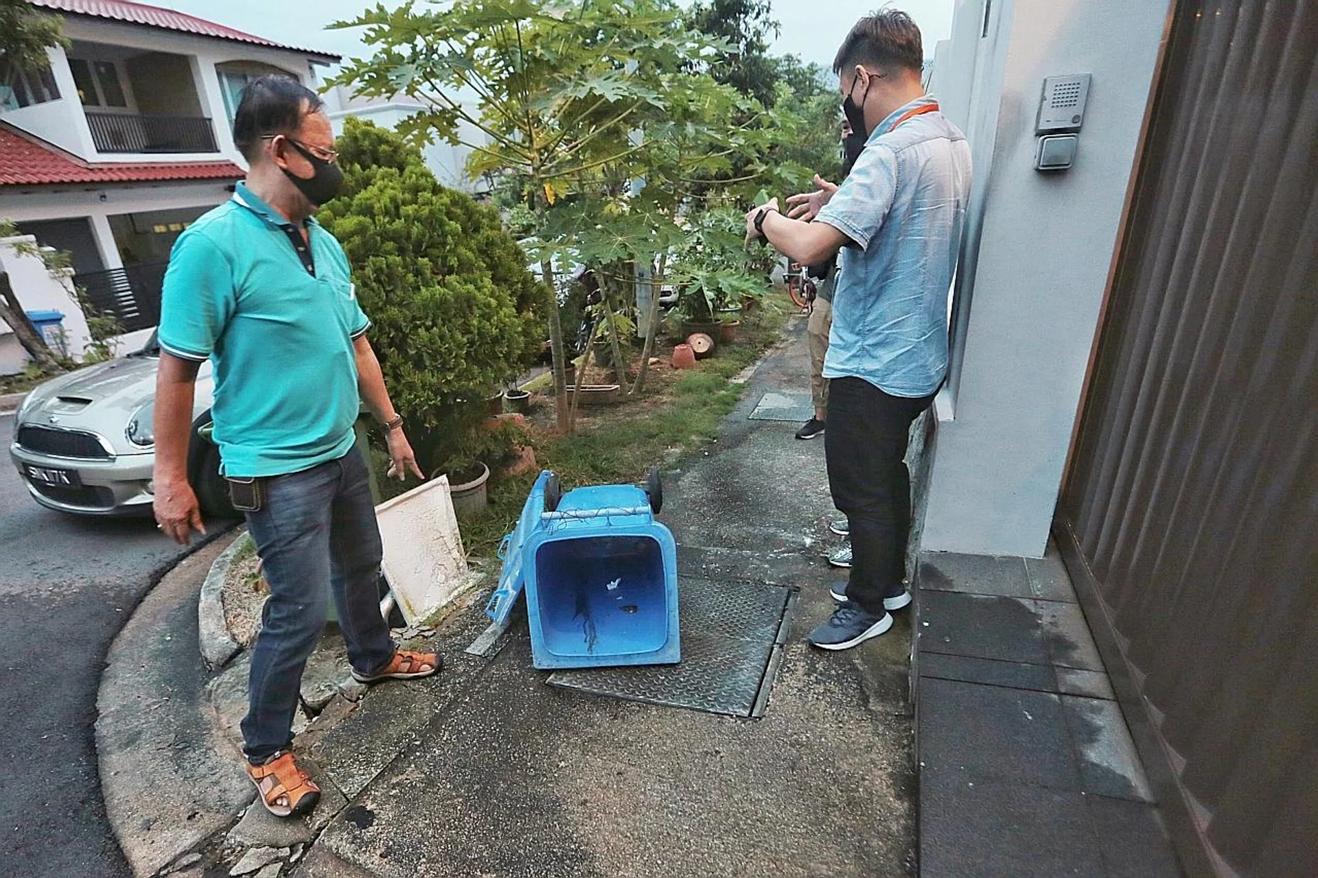 Mr Lew (left) recounting what happened when they found the infant in the bin outside his home. 