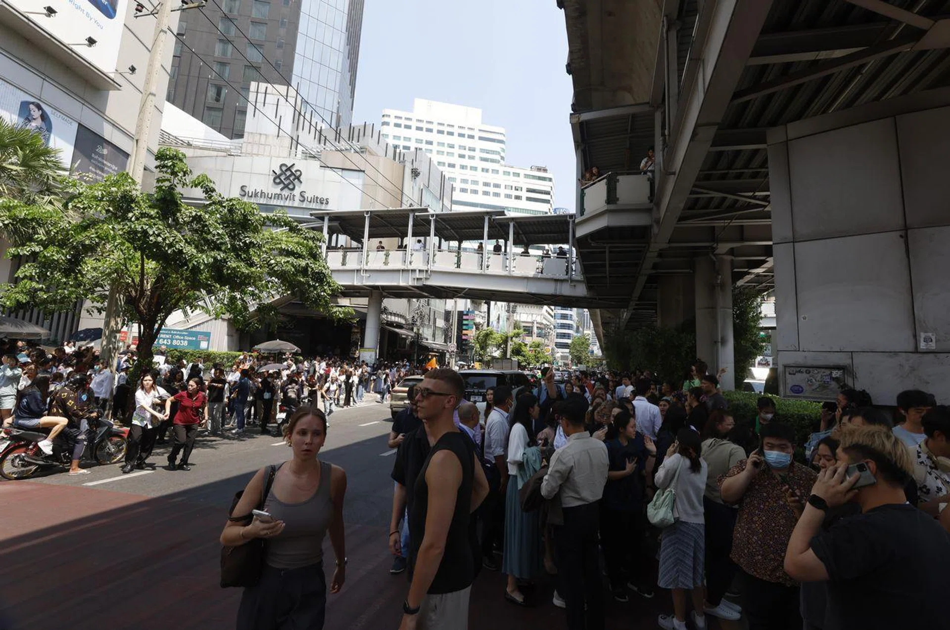 People gathering on a footpath outside a high-rise building in Bangkok on March 28.