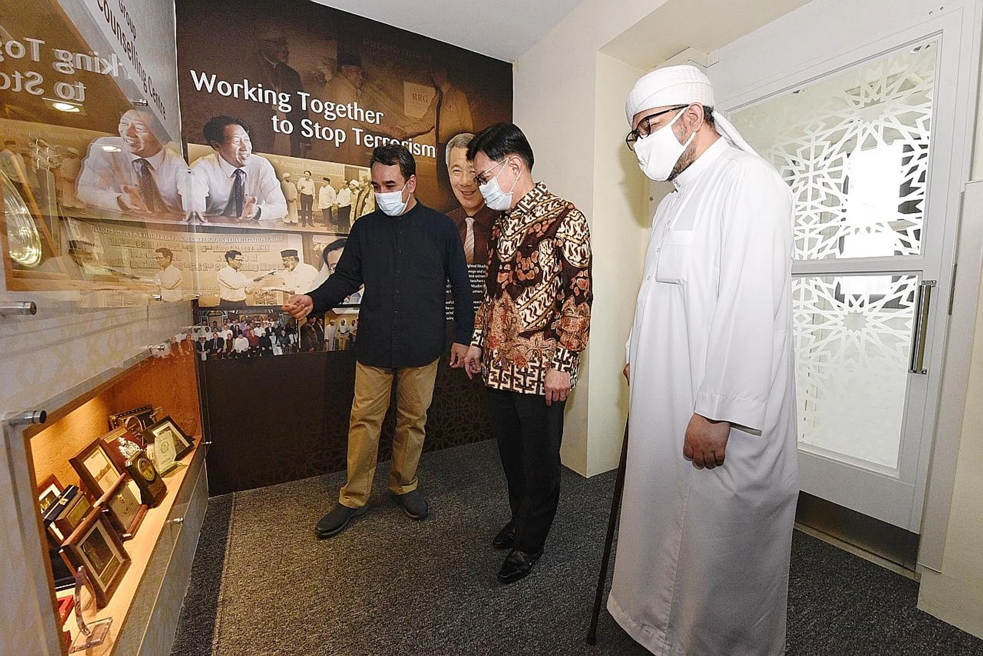 Deputy Prime Minister Heng Swee Keat (centre) visiting the gallery of the Resource and Counselling Centre run by the Religious Rehabilitation Group (RRG) at the Khadijah Mosque in Aljunied yesterday. With him are (left) RRG vice-chairman, Ustaz Mohamed Ali, and RRG co-chairman, Ustaz Hasbi Hassan. 