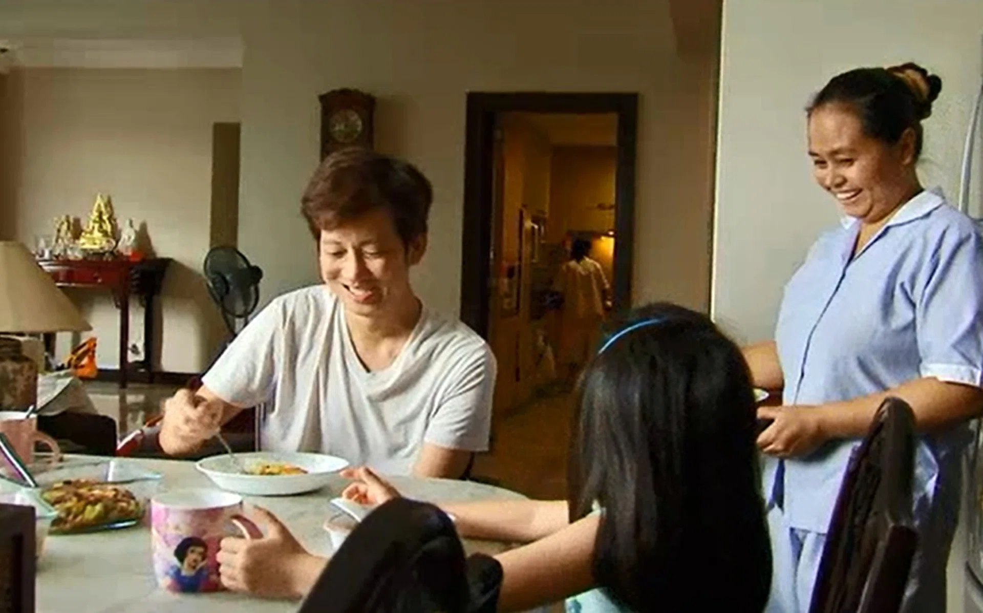 VISITING: Benjamin Heng with his family’s domestic helper Ms Yasinta at his home in Singapore (above) and at her home in East Java, Indonesia. 