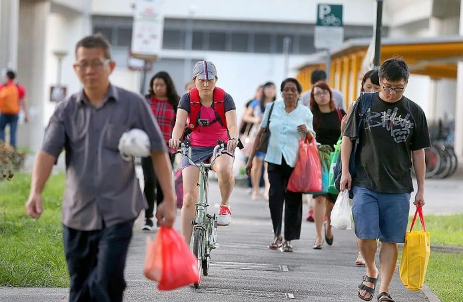 EXPERIMENT: TNP reporter Elizabeth Law (on bicycle) finds the shared path under the MRT tracks in Tampines wide enough for pedestrians and cyclists to share.