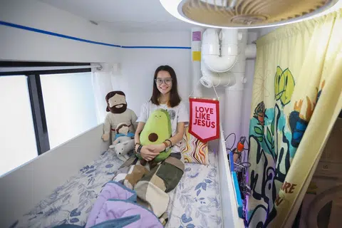 Ms Sasha Marie Shelley on her bunk bed in her bedroom, which was originally the service yard of her family's flat.