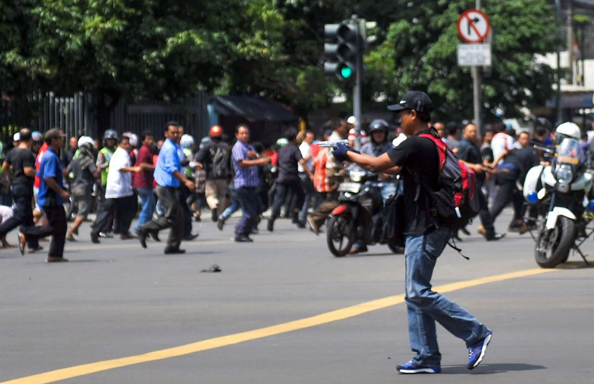 A gunman points his weapon on the street during attacks in the Indonesian capital Jakarta on January 14, 2016.