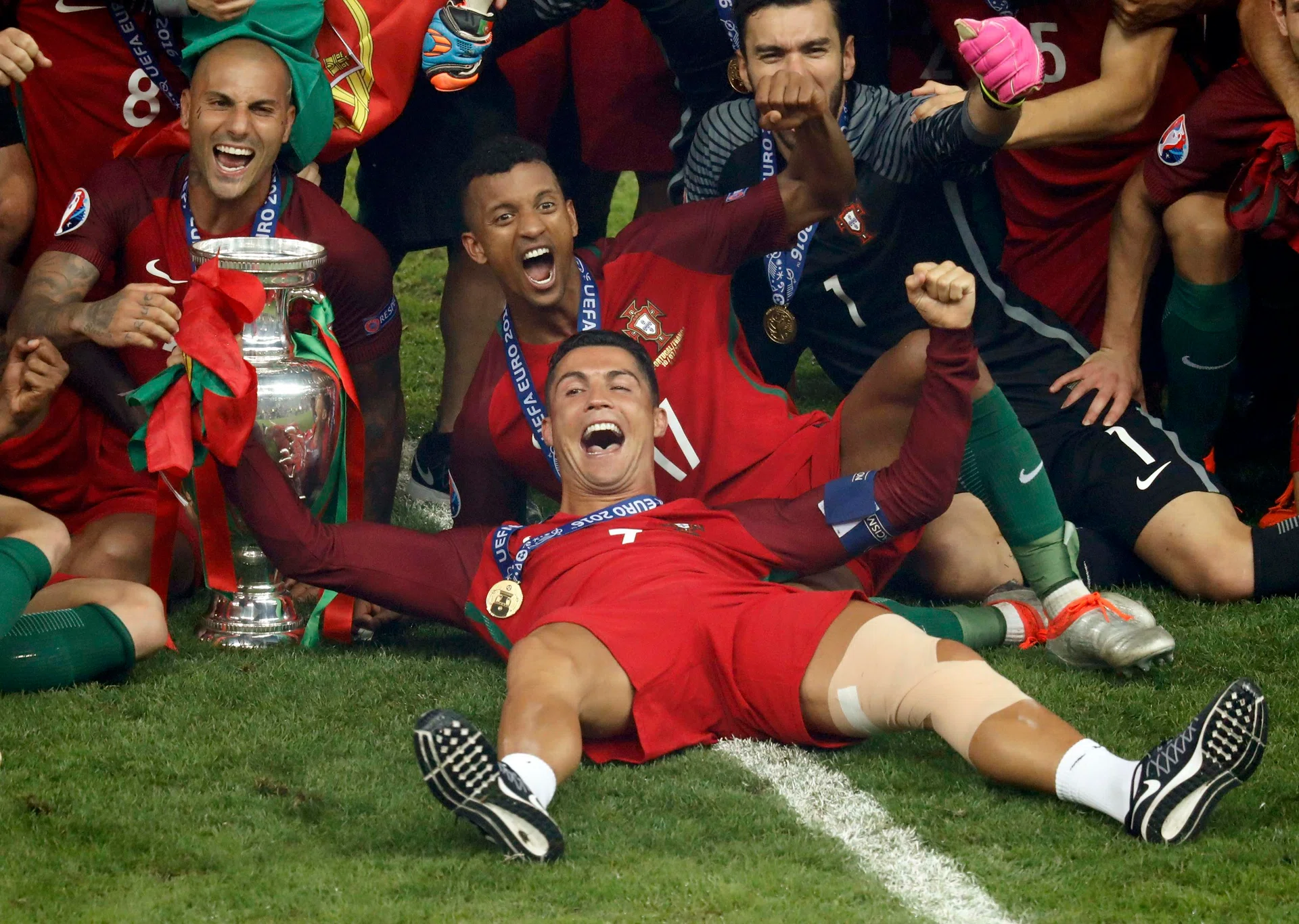 FROM TEARS TO CHEERS: Ronaldo celebrates with teammates and trophy.   