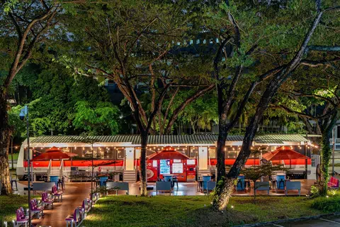 The outdoor dining area is furnished with original MRT train seats and bicycle racks.
