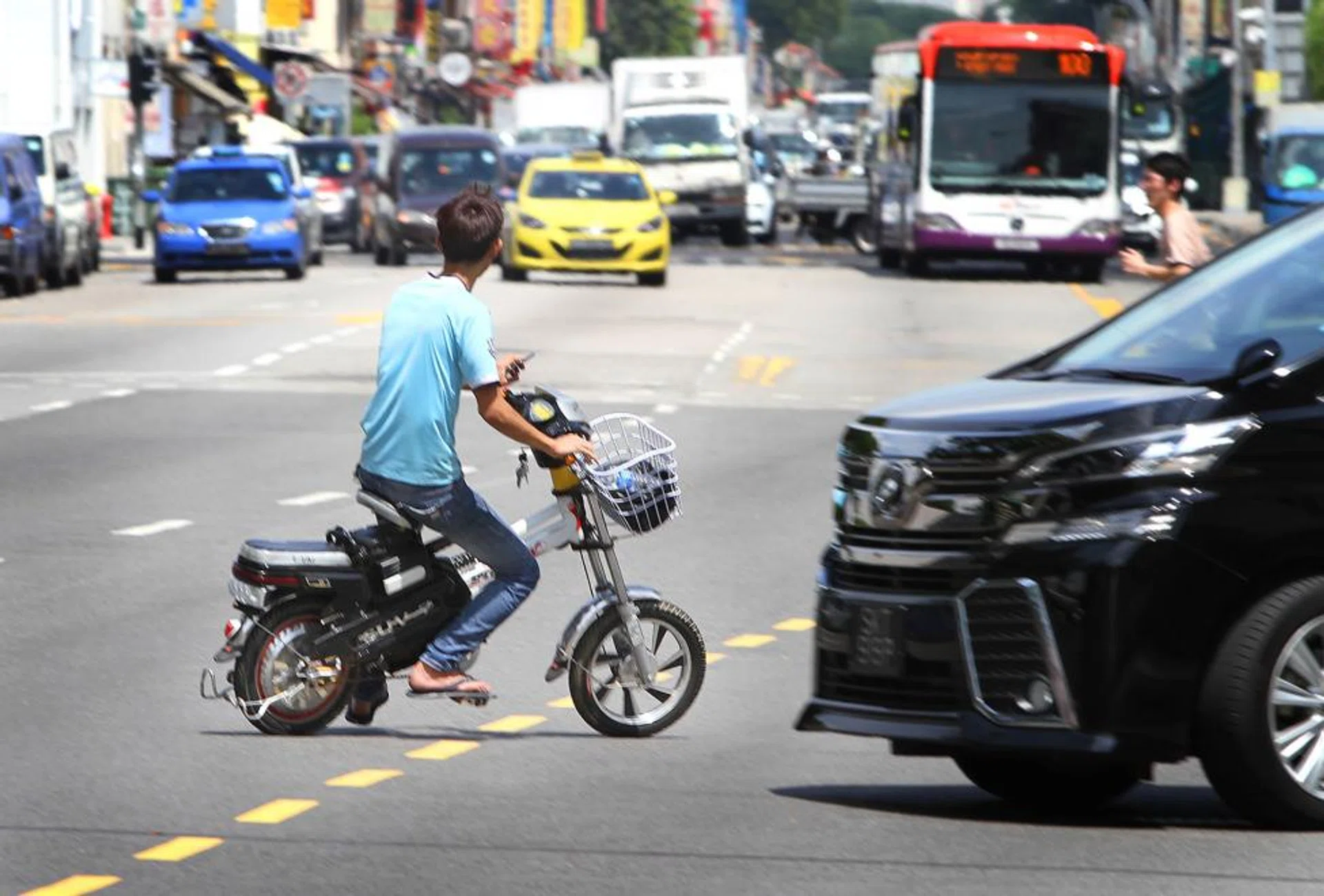 An e-biker in Geylang riding against the flow of traffic, cutting across lanes. He also did not wear a helmet.